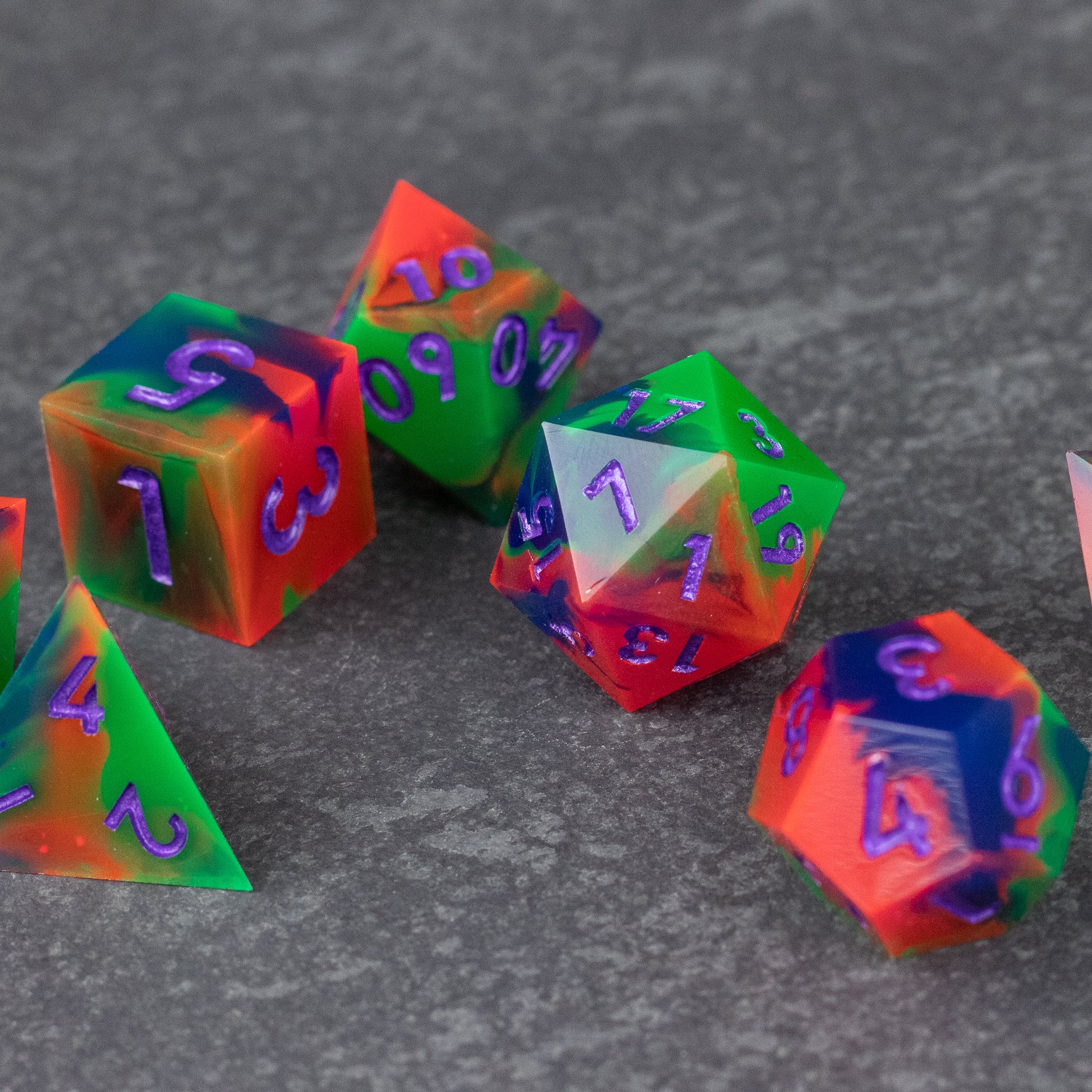 Neon Demon Dice Set - Set of sharp-edged dice with neon green, pink, and purple colors, featuring translucent surfaces and bright numbered.