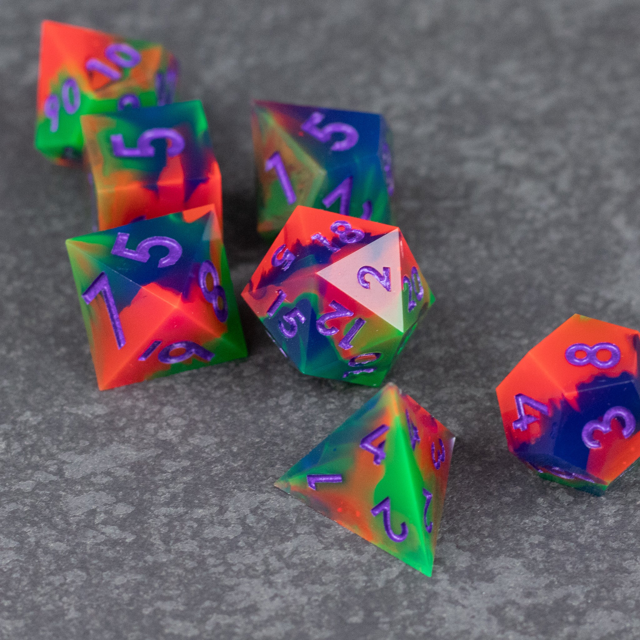 Neon Demon Dice Set - Set of neon green, pink, and purple sharp-edged polyhedral dice with vibrant gradient colors and contrasting numbers.