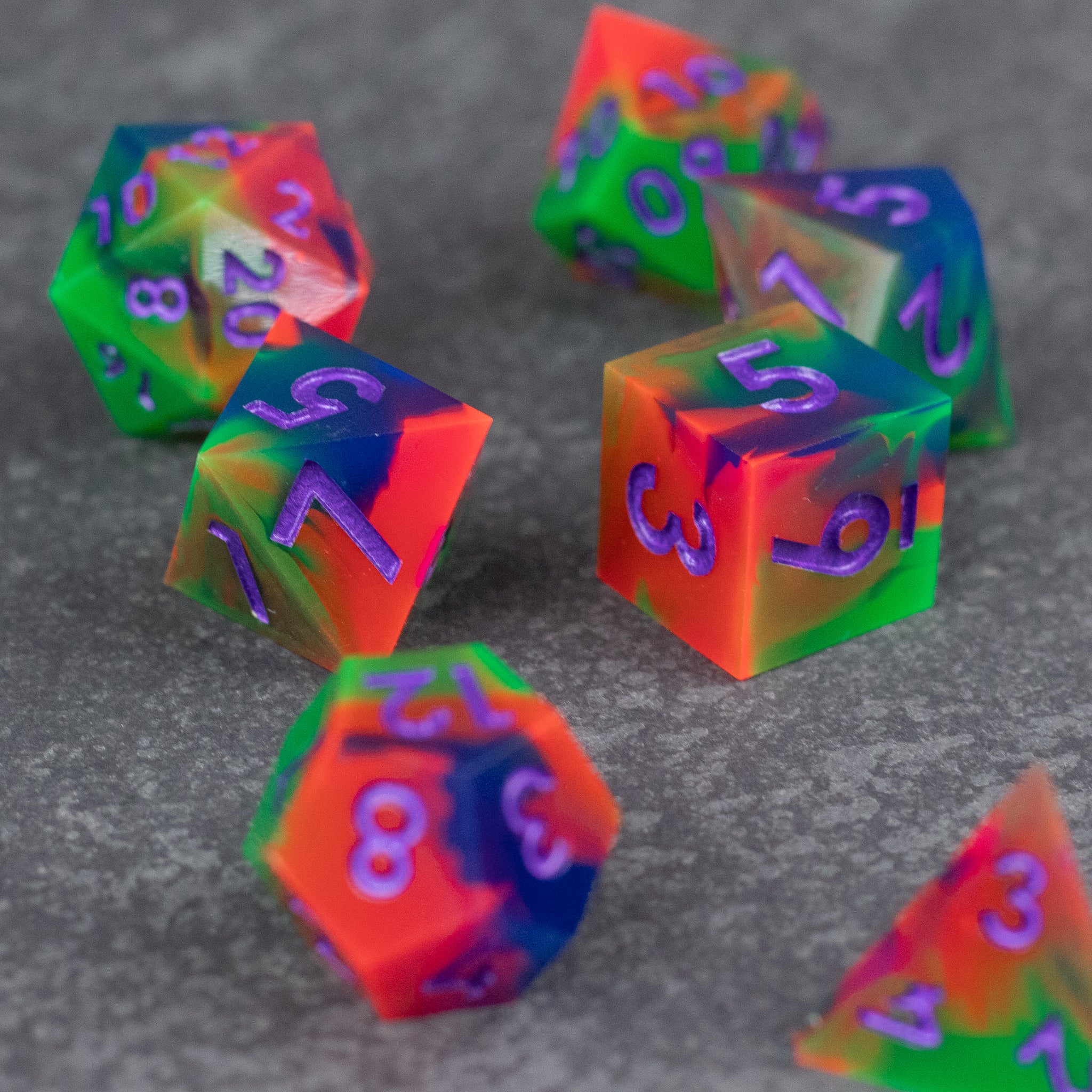 Neon Demon Dice Set - Colorful translucent dice set with sharp edges featuring neon green, pink, orange, and purple hues.