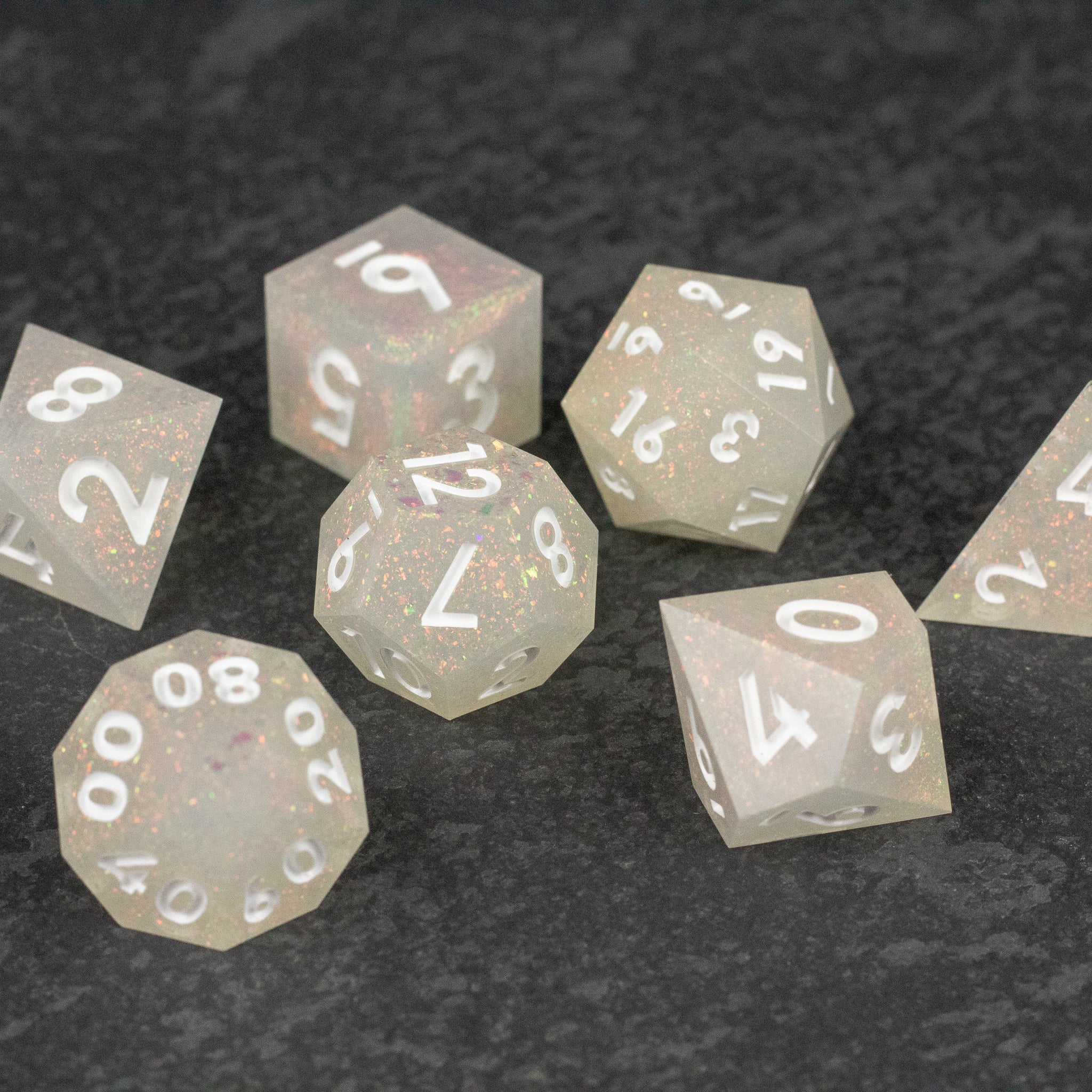 Snowfield Dice Set - Translucent white seven-piece polyhedral dice set with sharp edges and white numbering.