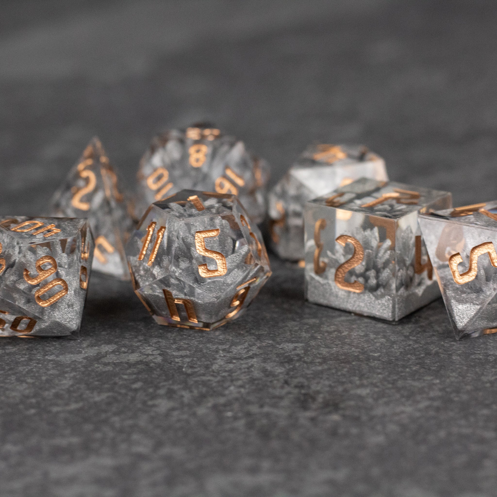 Silver Crystal Dice Set - Set of silver crystal polyhedral dice with sharp edges and copper-gold numbering.