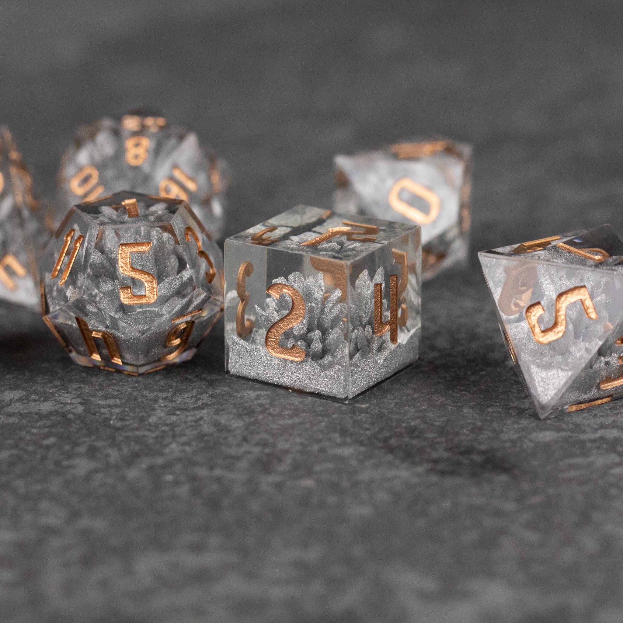 Silver Crystal Dice Set - Set of silver crystal polyhedral dice with sharp edges and metallic gold numbers.