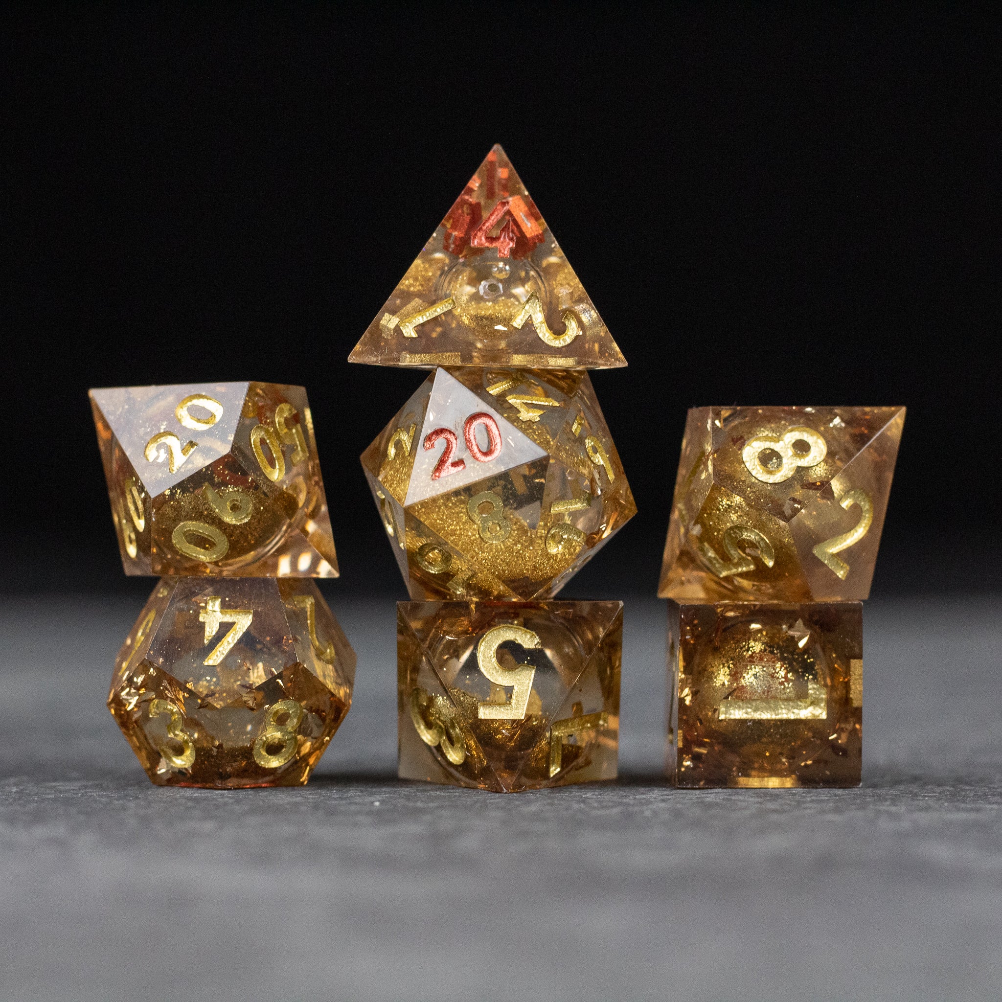 Dragon's Hoard Liquid Core Dice Set - Gold liquid core sharp-edged polyhedral dice set with intricate swirling patterns.