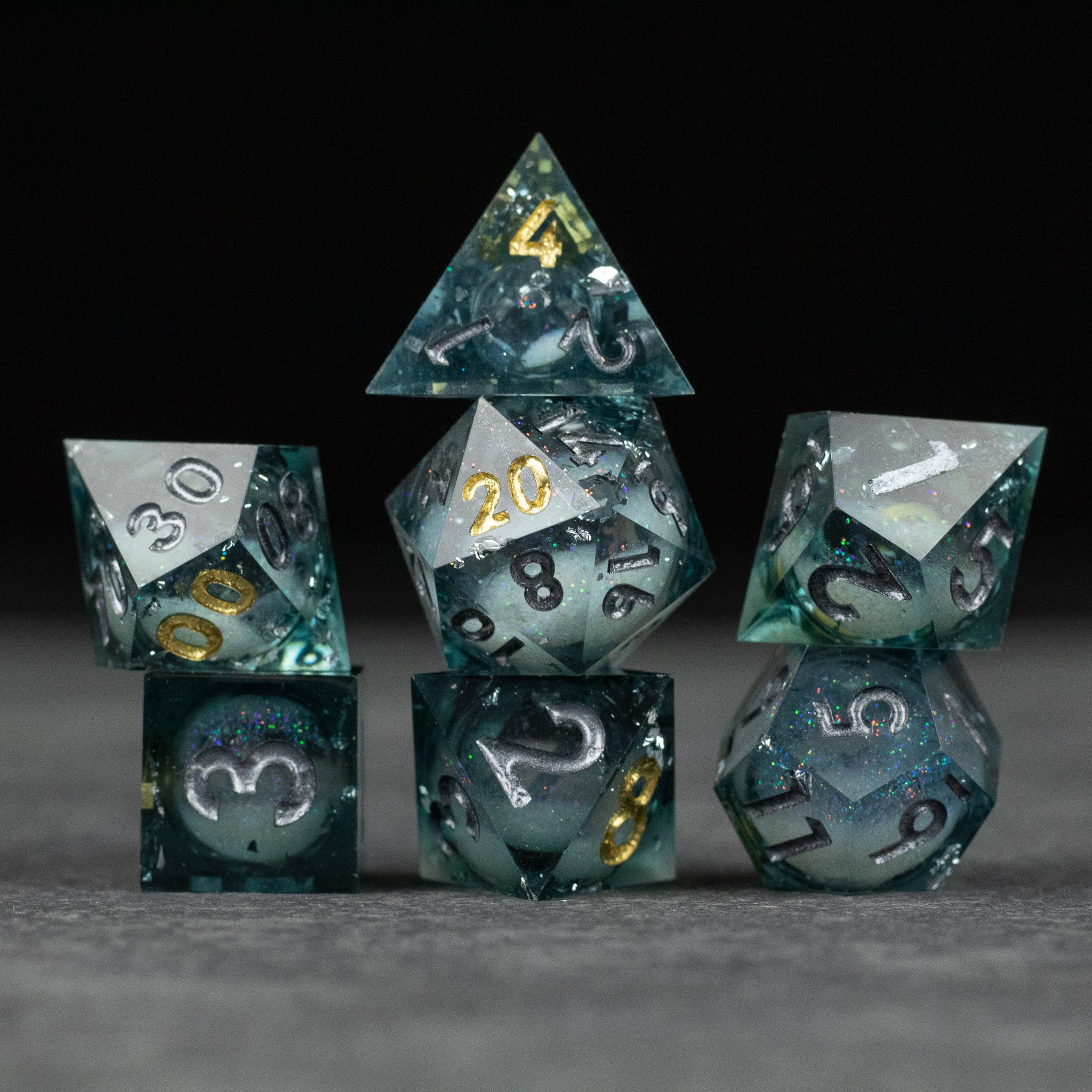 Call Of The Deep - Liquid Core Dice Set - Set of seven translucent dark blue liquid core dice with sharp edges, gold and white numbering.