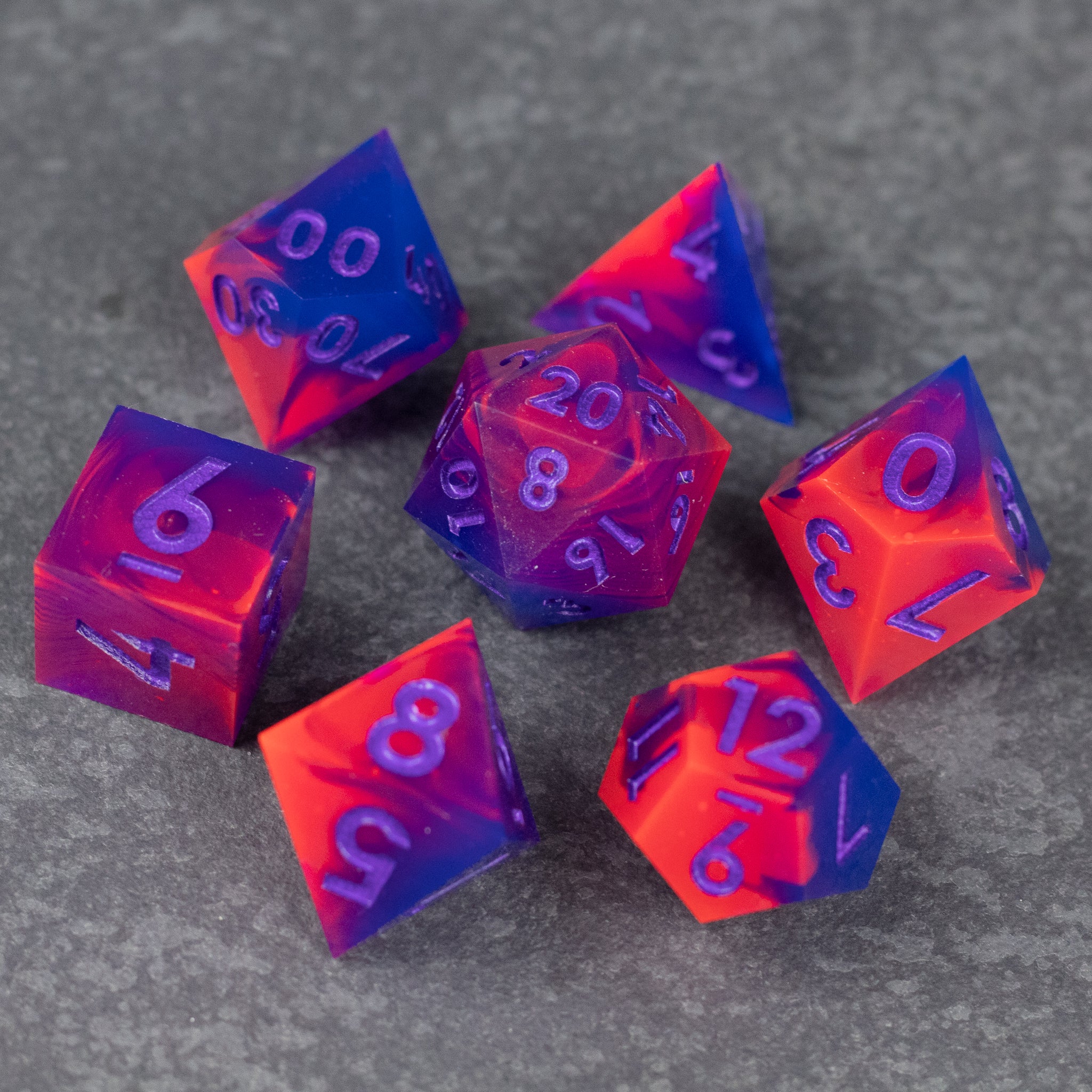 Outrun Dice Set - Set of seven neon orange and purple sharp-edged polyhedral dice on gray surface.