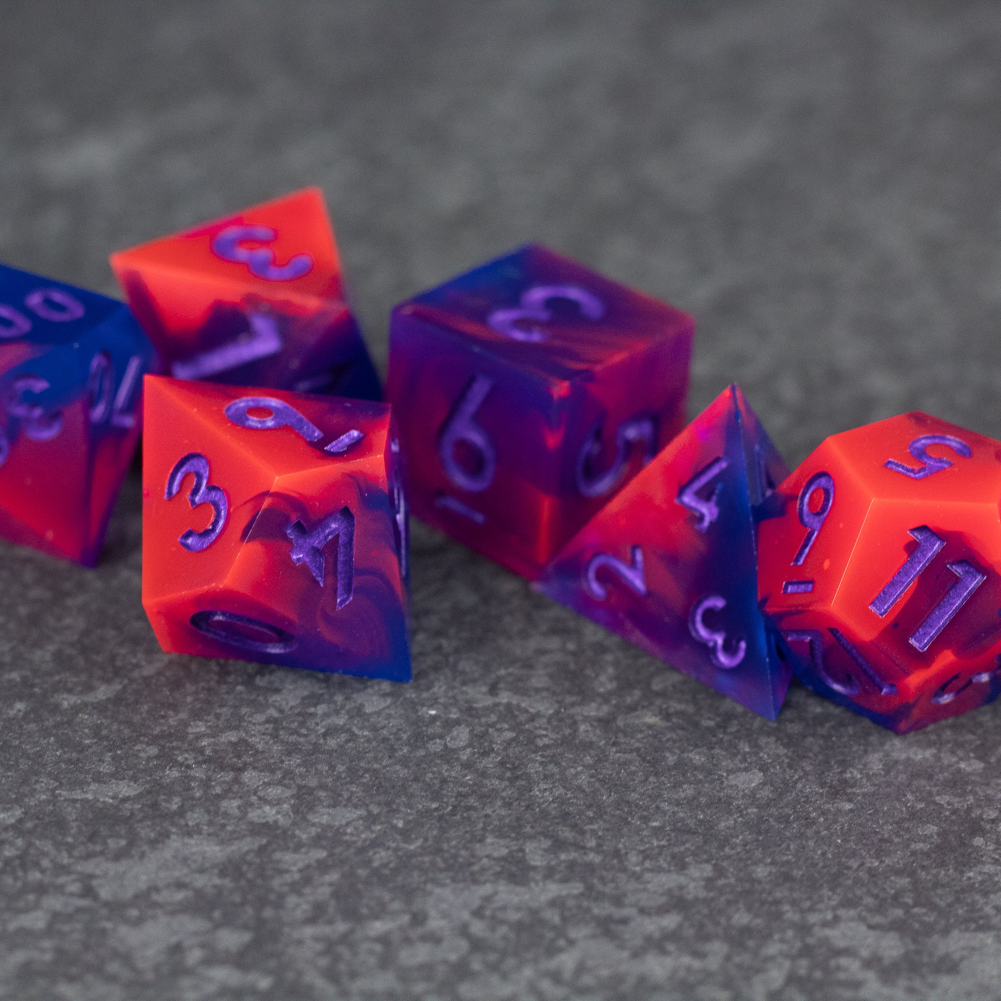 Outrun Dice Set - Set of six sharp-edged dice in neon orange and purple with contrasting bold numbers.