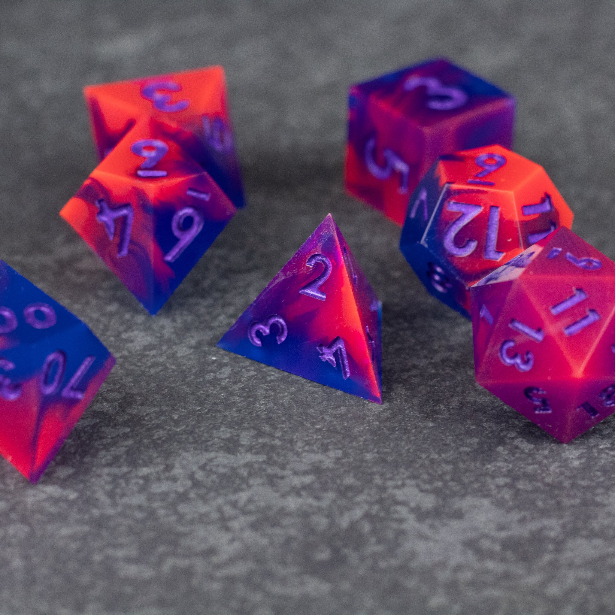 Outrun Dice Set - Sharp-edged polyhedral dice set with neon orange and purple gradient, translucent with purple numbers.