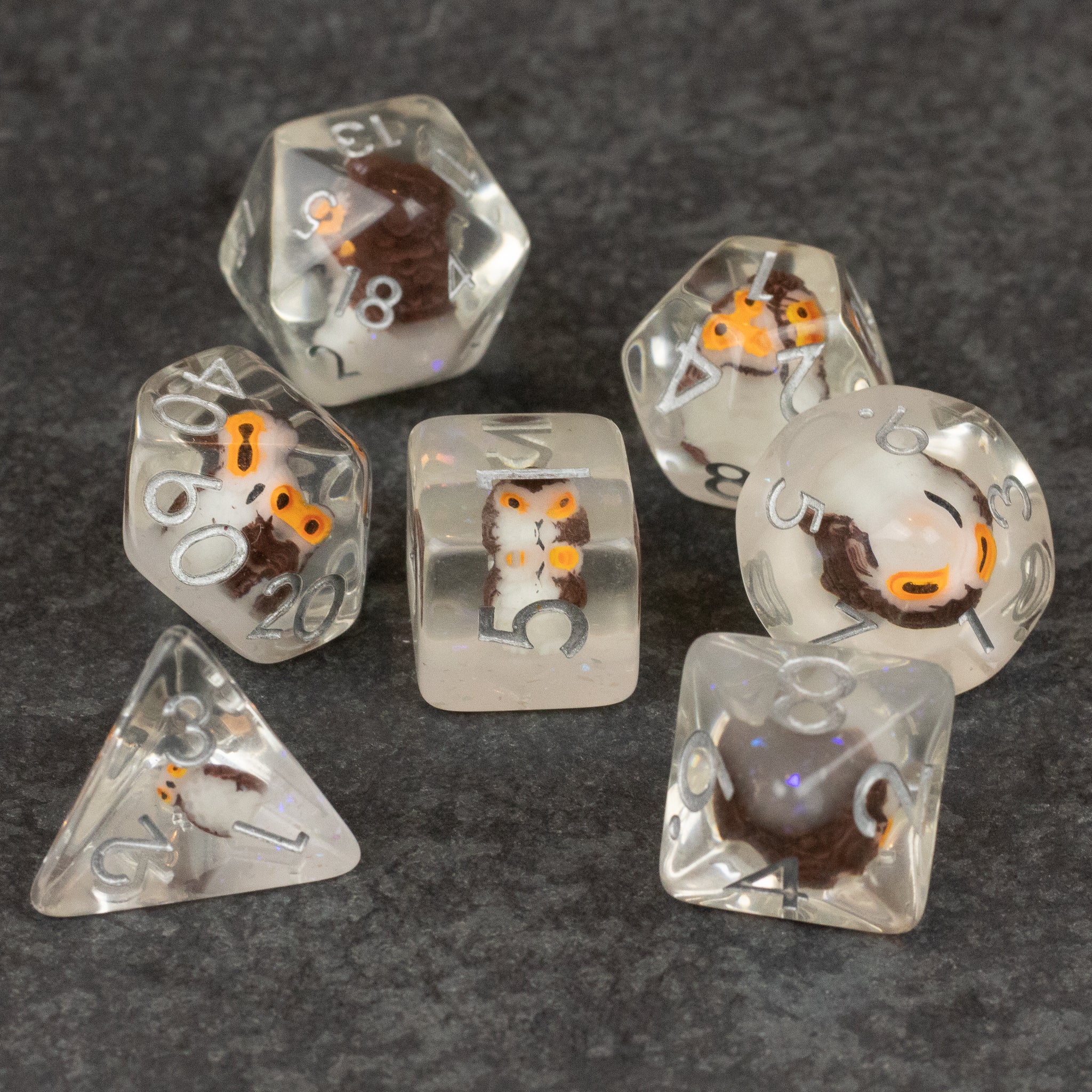 Owl Dice Set - Clear polyhedral dice set with orange and black owl designs inside, various shapes and numbers visible.
