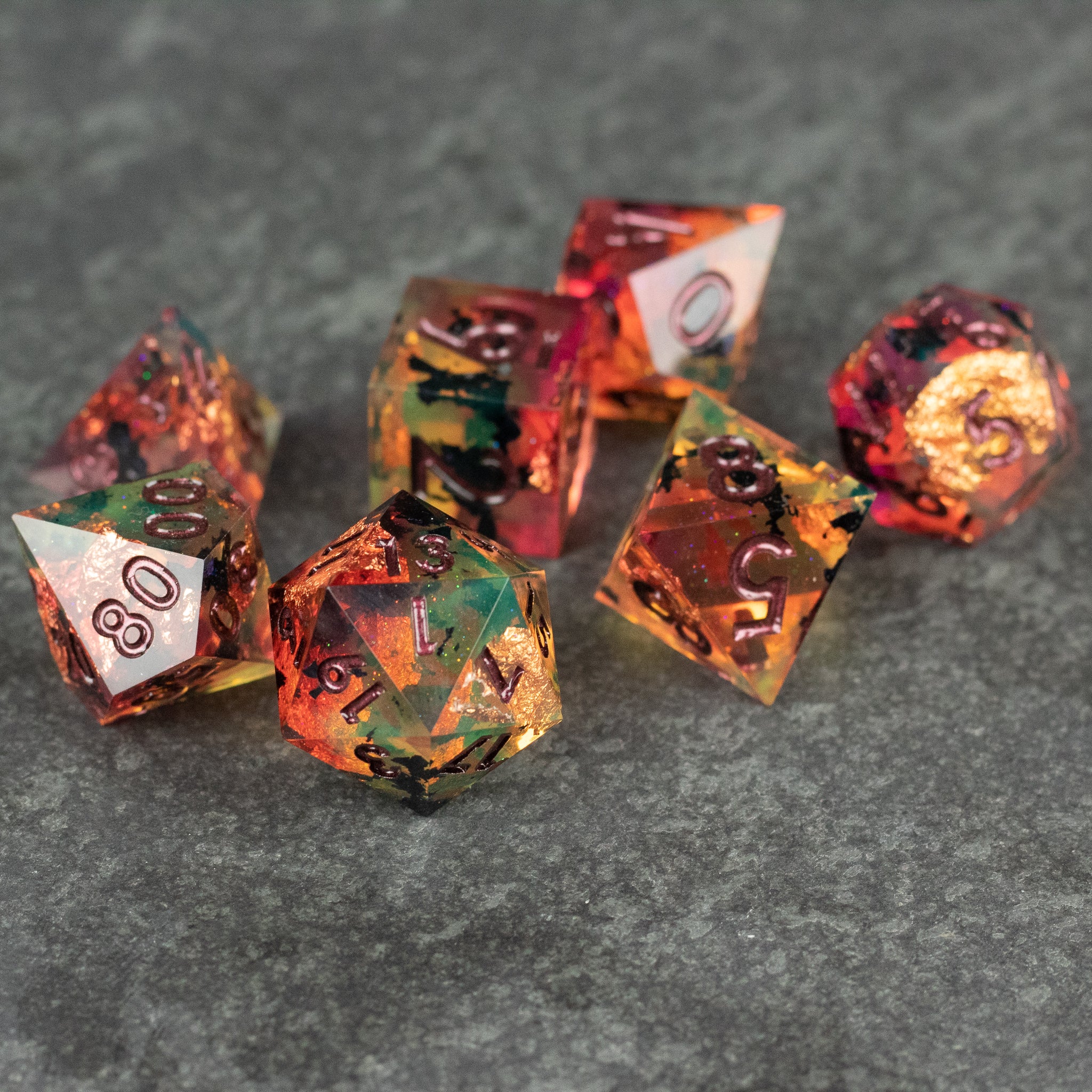 Dawn Ritual Dice Set - Sharp-edged polyhedral dice set with orange, red, and green swirls and black numbering.
