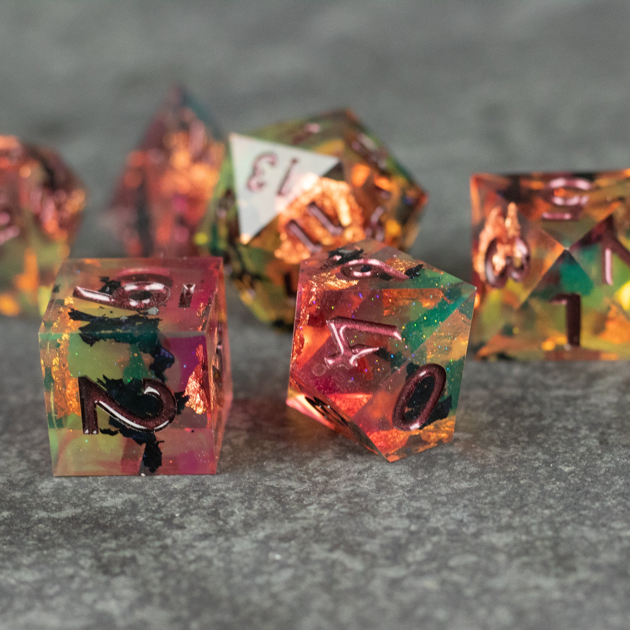 Dawn Ritual Dice Set - Translucent polyhedral dice set with sharp edges, featuring swirling shades of orange, green, and yellow with black.