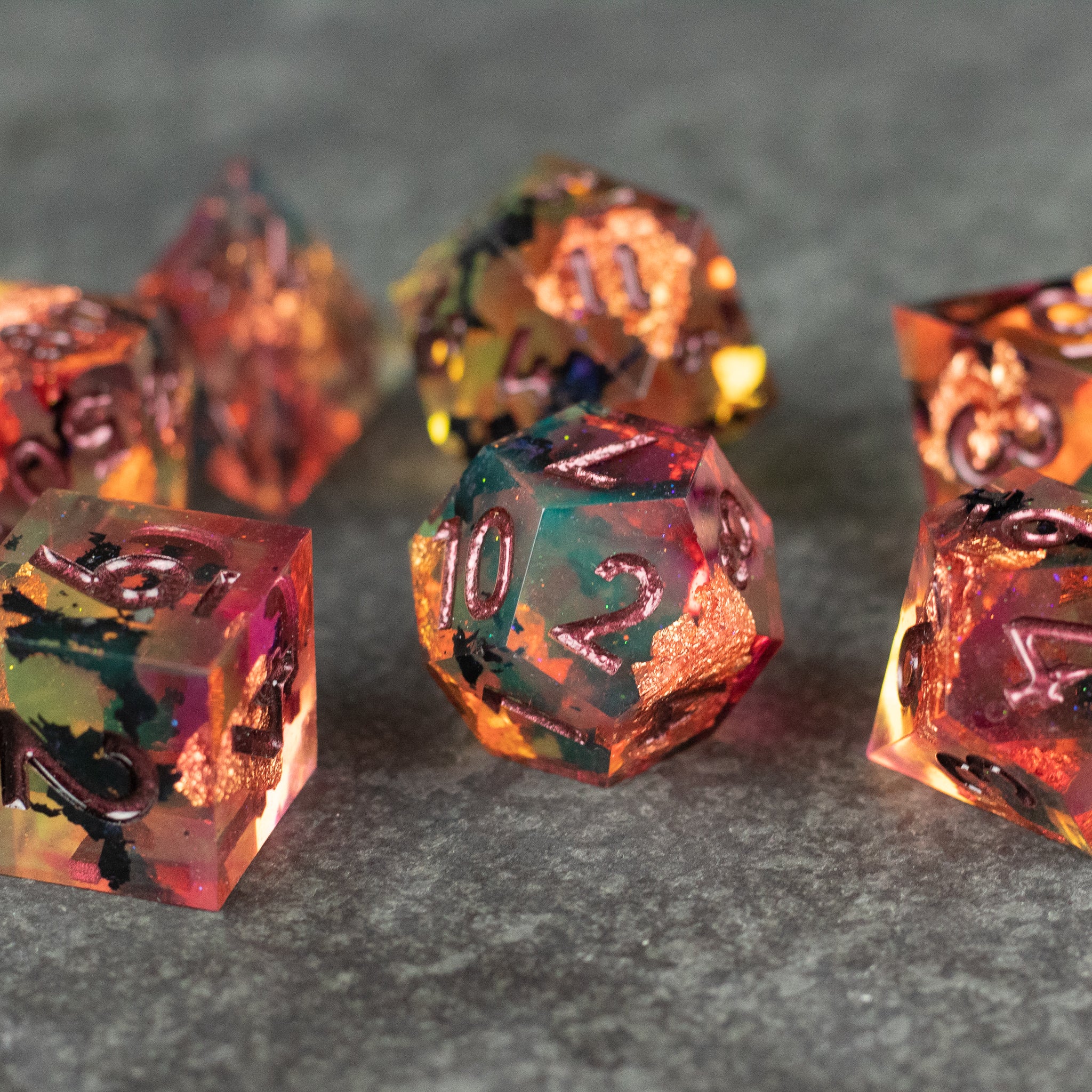 Dawn Ritual Dice Set - Set of translucent polyhedral dice in fiery orange, red, and black tones with sharp edges and metallic numerals.