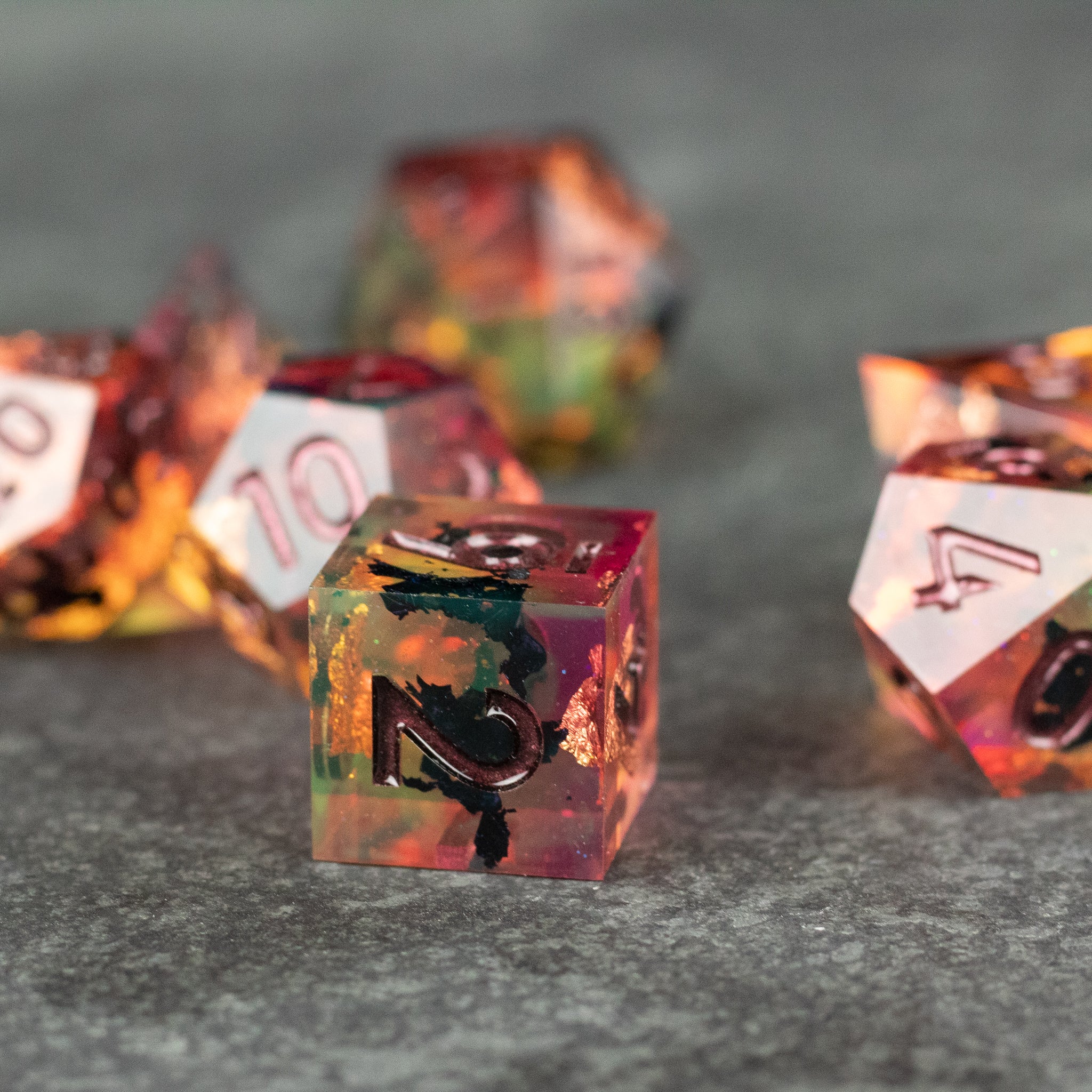Dawn Ritual Dice Set - Translucent sharp-edge polyhedral dice with orange, yellow, and green inclusions and black numbering.