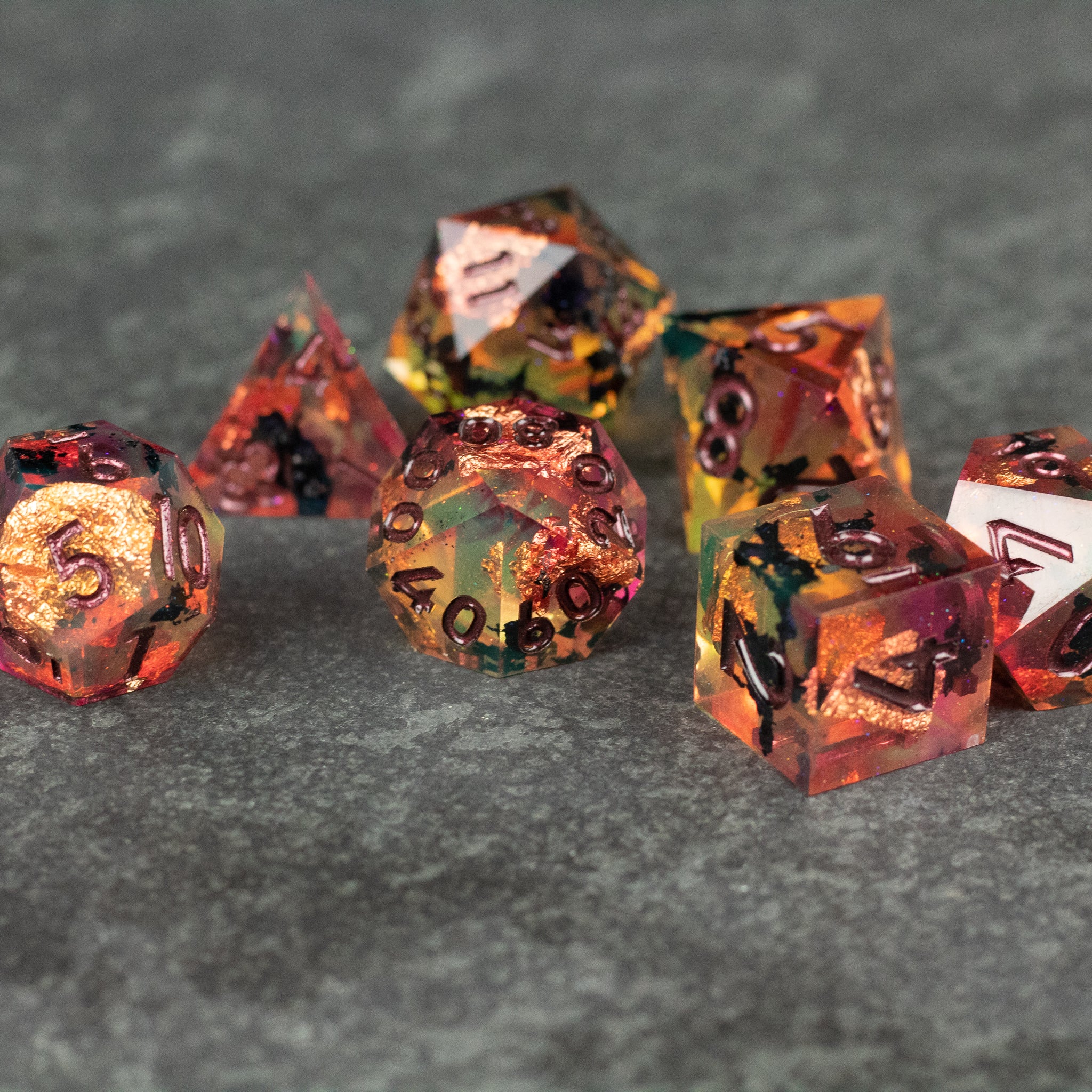 Dawn Ritual Dice Set - Sharp-edged polyhedral dice set with fiery orange, red, and gold swirls on gray background.