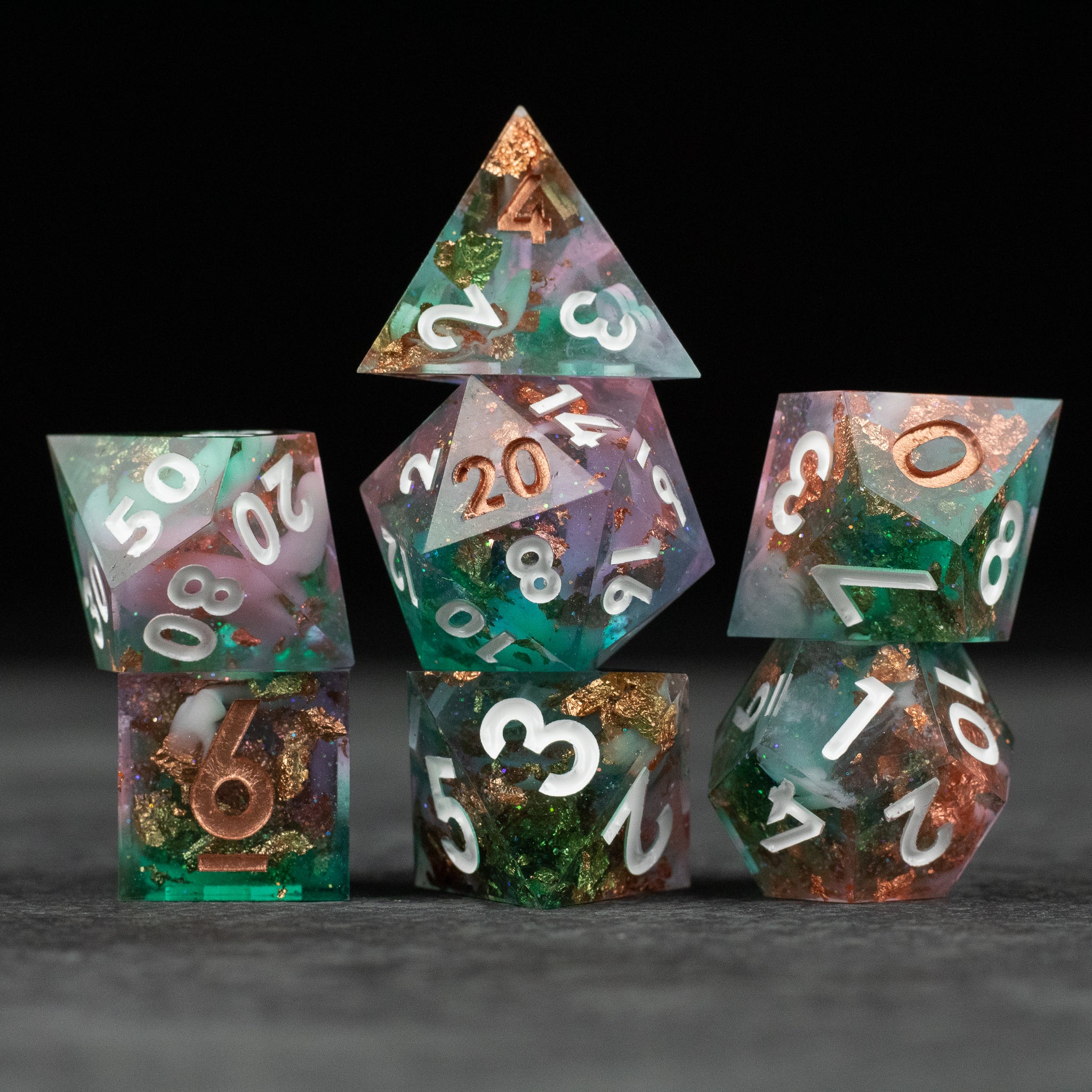 Scapeshift Dice Set - Green and purple sharp edge polyhedral dice set with white numbers and copper accents.
