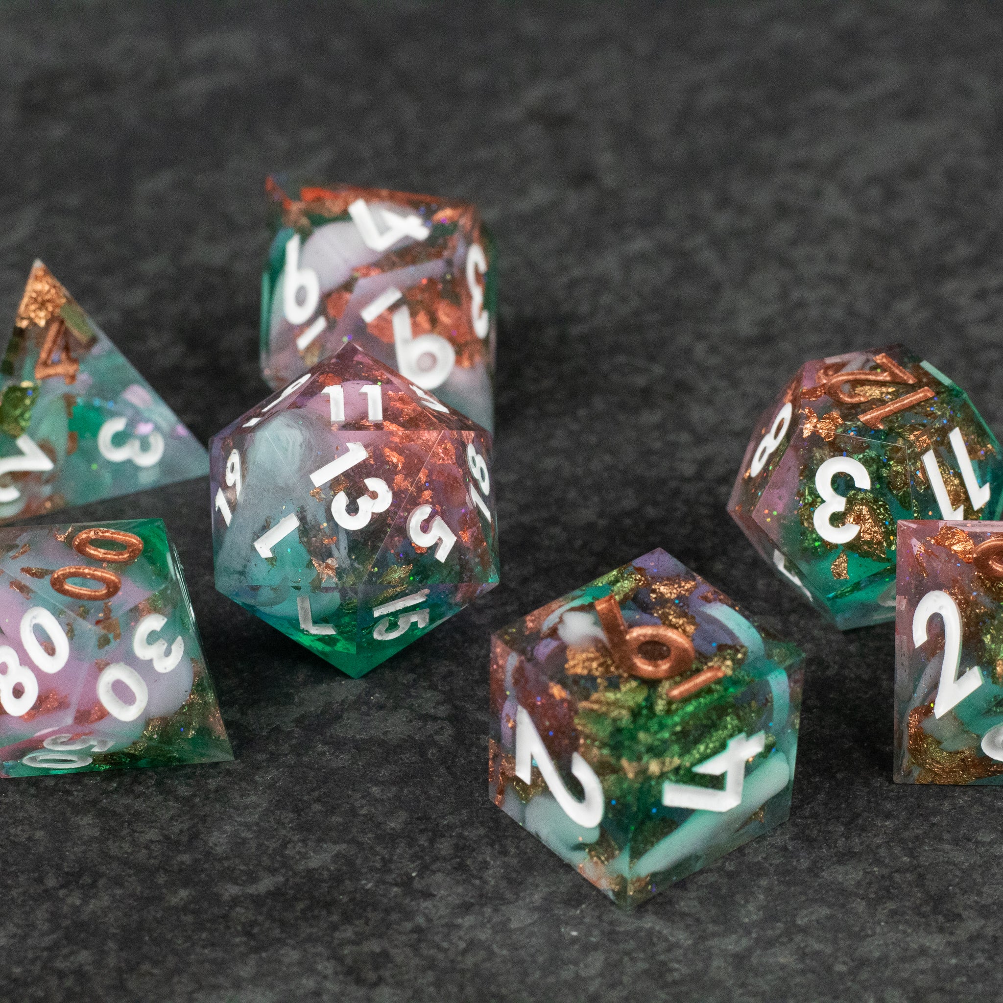 Scapeshift Dice Set - Set of sharp-edged dice in green, orange, and clear resin with white numbering.