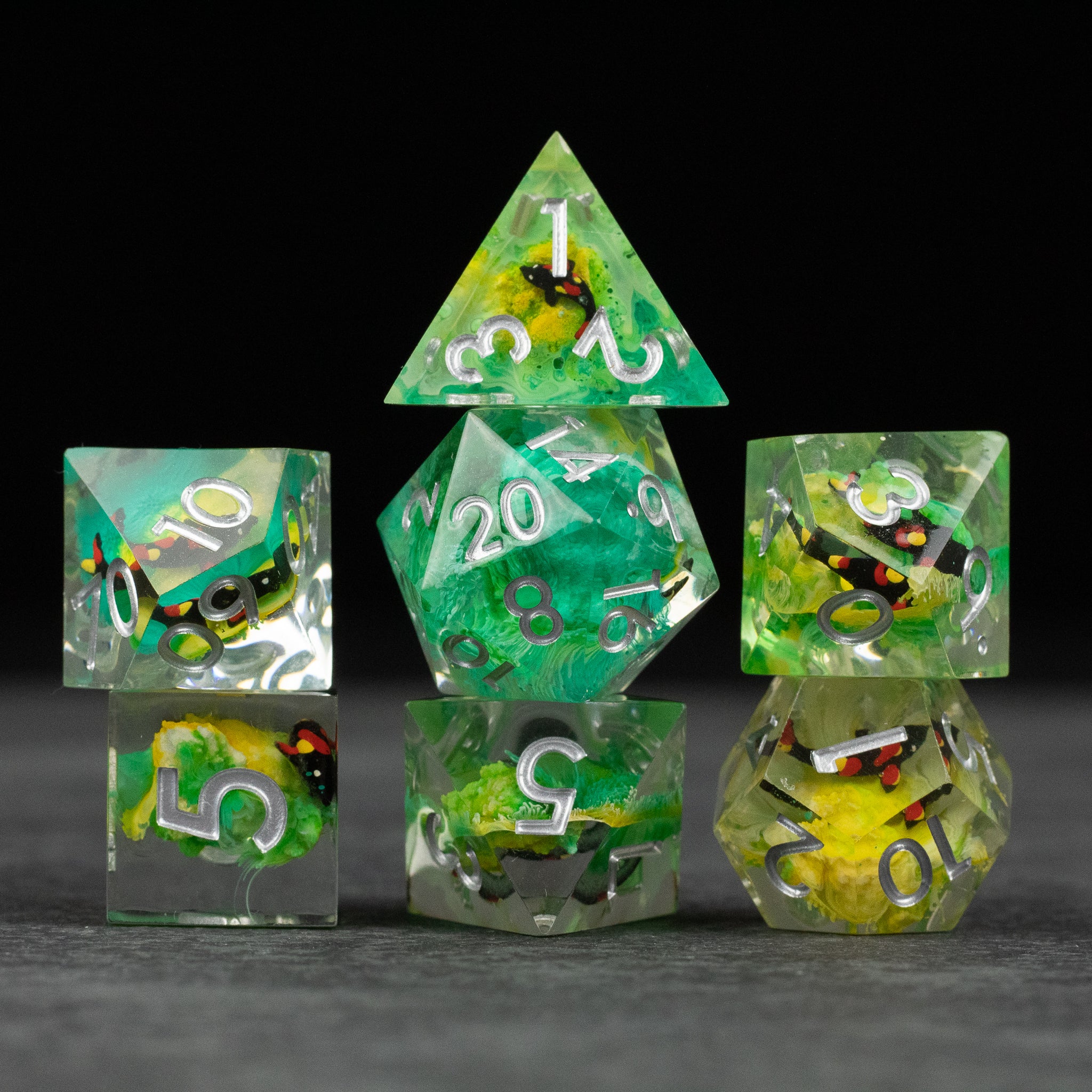 Green Lagoon Dice Set - Set of seven sharp-edged green translucent dice with colorful inclusions and white numbering.