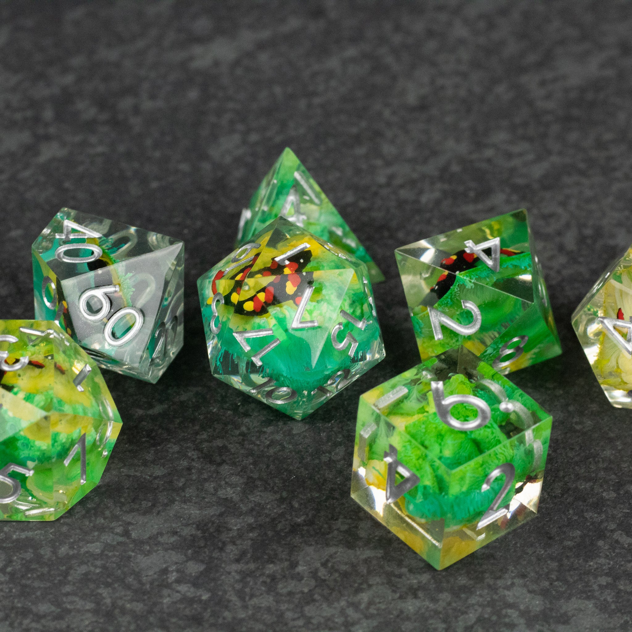 Green Lagoon Dice Set - Sharp-edged green and yellow translucent polyhedral dice with white numbering on dark background.