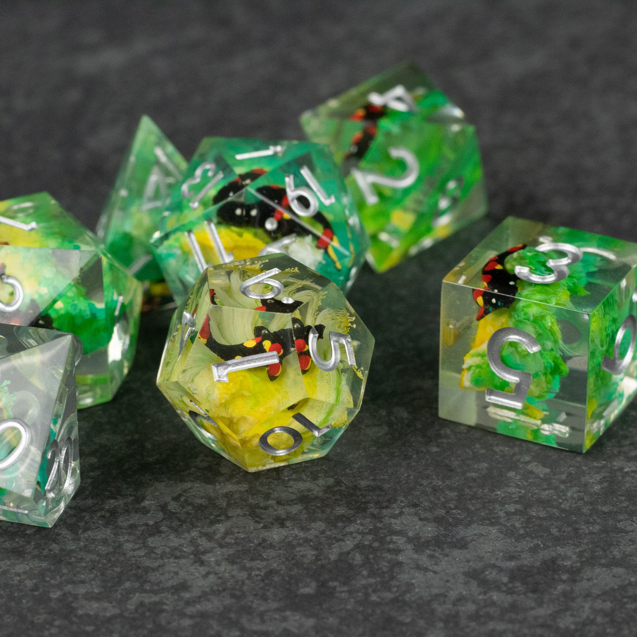 Green Lagoon Dice Set - Set of translucent sharp-edged dice in green with colorful internal inclusions and white numbering.