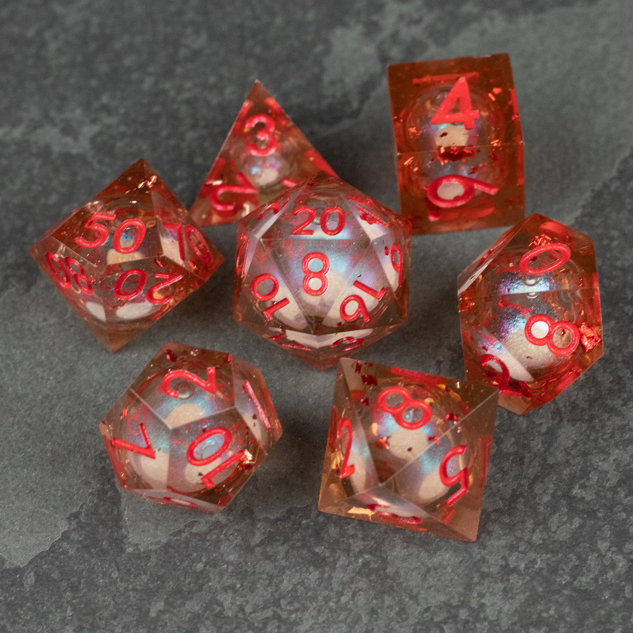 Potion of Fire Breath - Liquid Core Dice Set - Seven translucent orange polyhedral dice with red numbering and liquid core, sharp edges on each die.