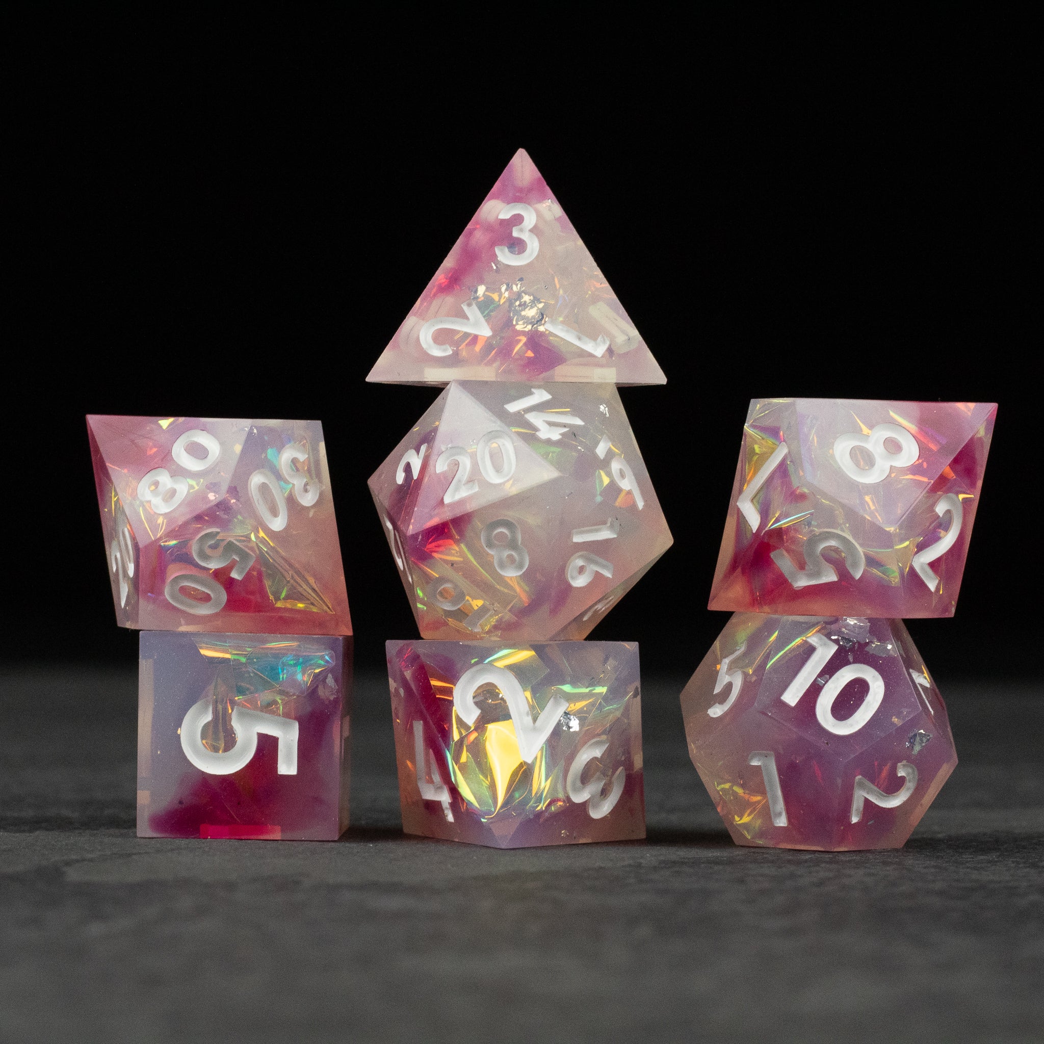 Lover's Kiss Dice Set - Pink and white marbled sharp edge dice set with silver numbers, including d4, d6, d8, d10, d12, and d20.