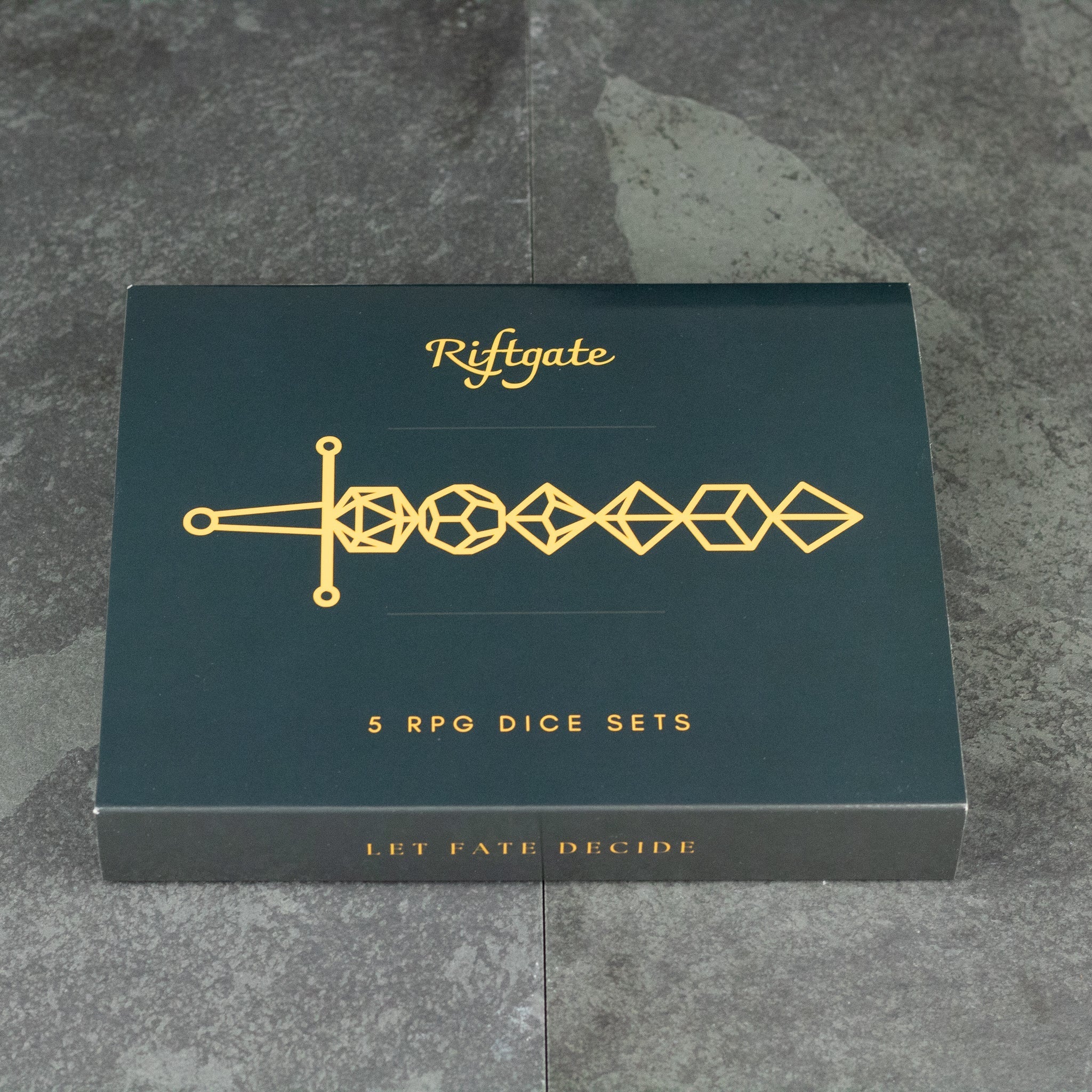 Acrylic Dice Set Gift Box - Black gift box with gold geometric sword design and text, containing five RPG acrylic dice sets.