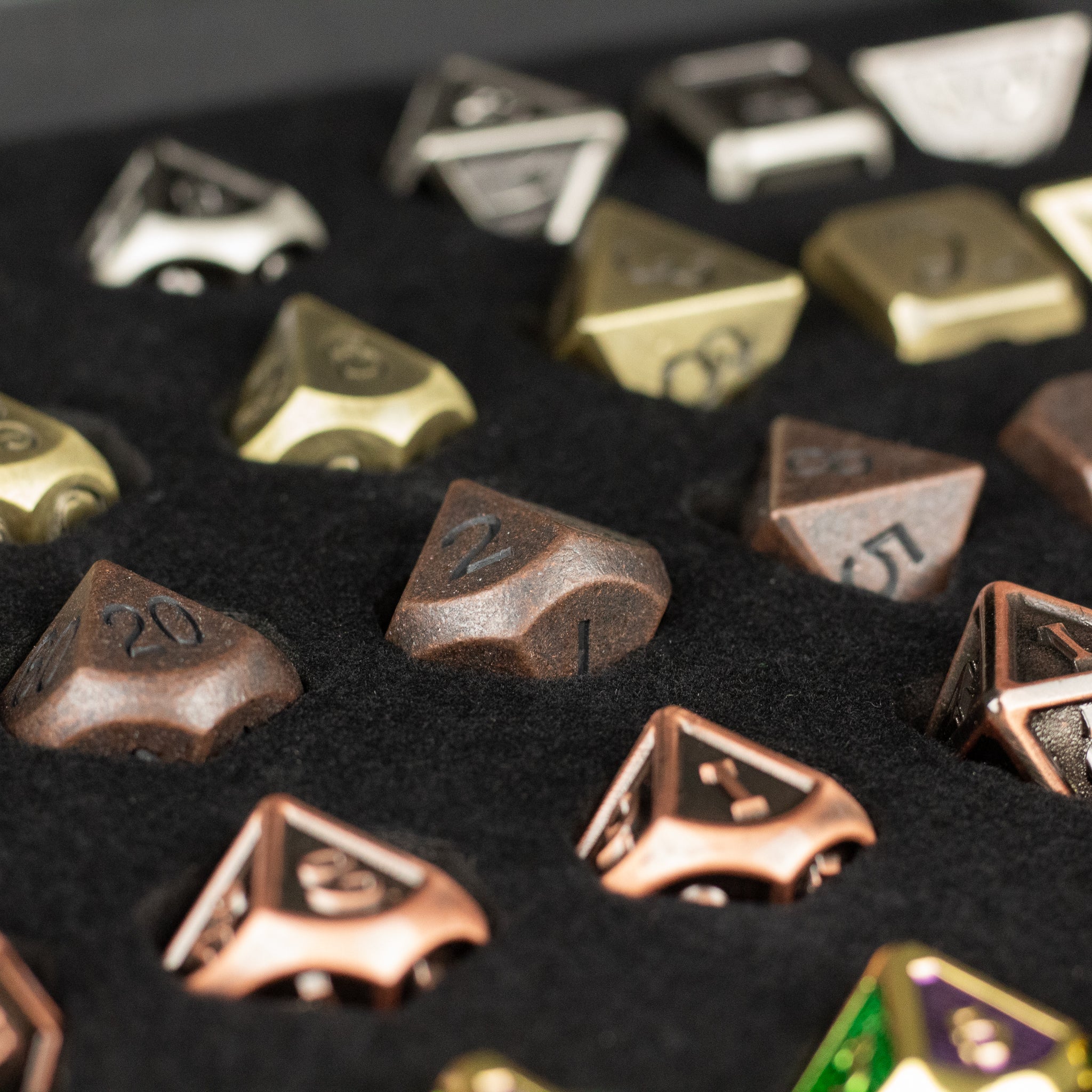 Metal Dice Set Gift Box - Set of metal polyhedral dice in bronze, silver, gold, and copper tones with etched numbers in a black foam gift box.