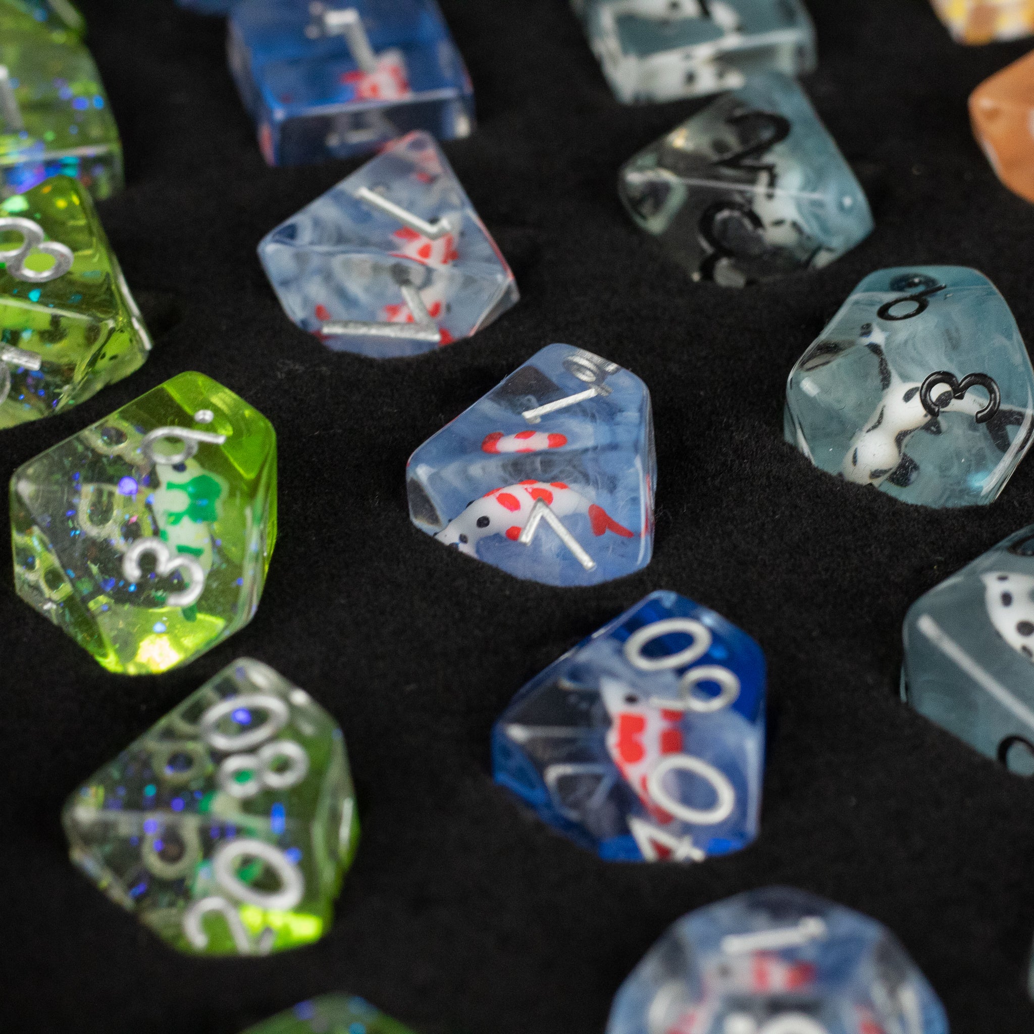 Koi Fish Dice Set Gift Box - Polyhedral dice set with koi fish designs in blue, green, and translucent colors on black background.