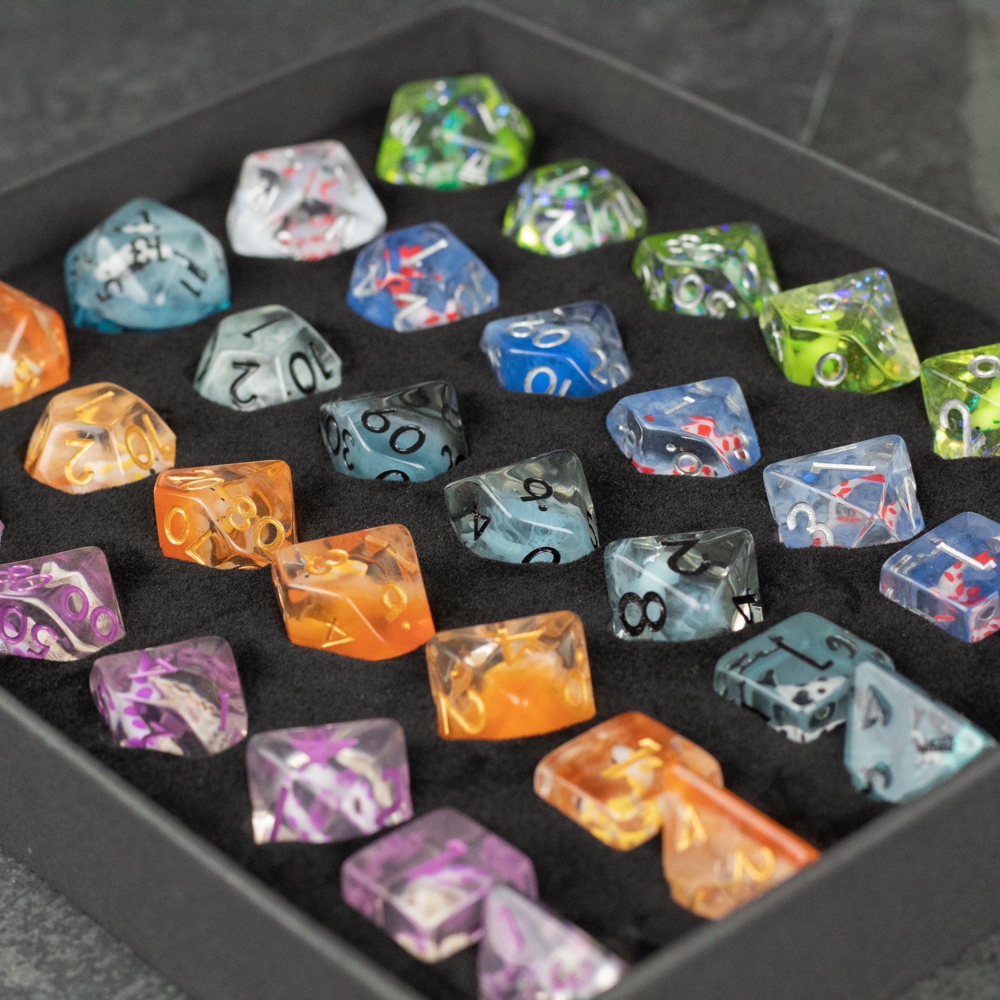 Koi Fish Dice Set Gift Box - Colorful translucent polyhedral dice with koi fish designs inside, arranged in a black gift box.