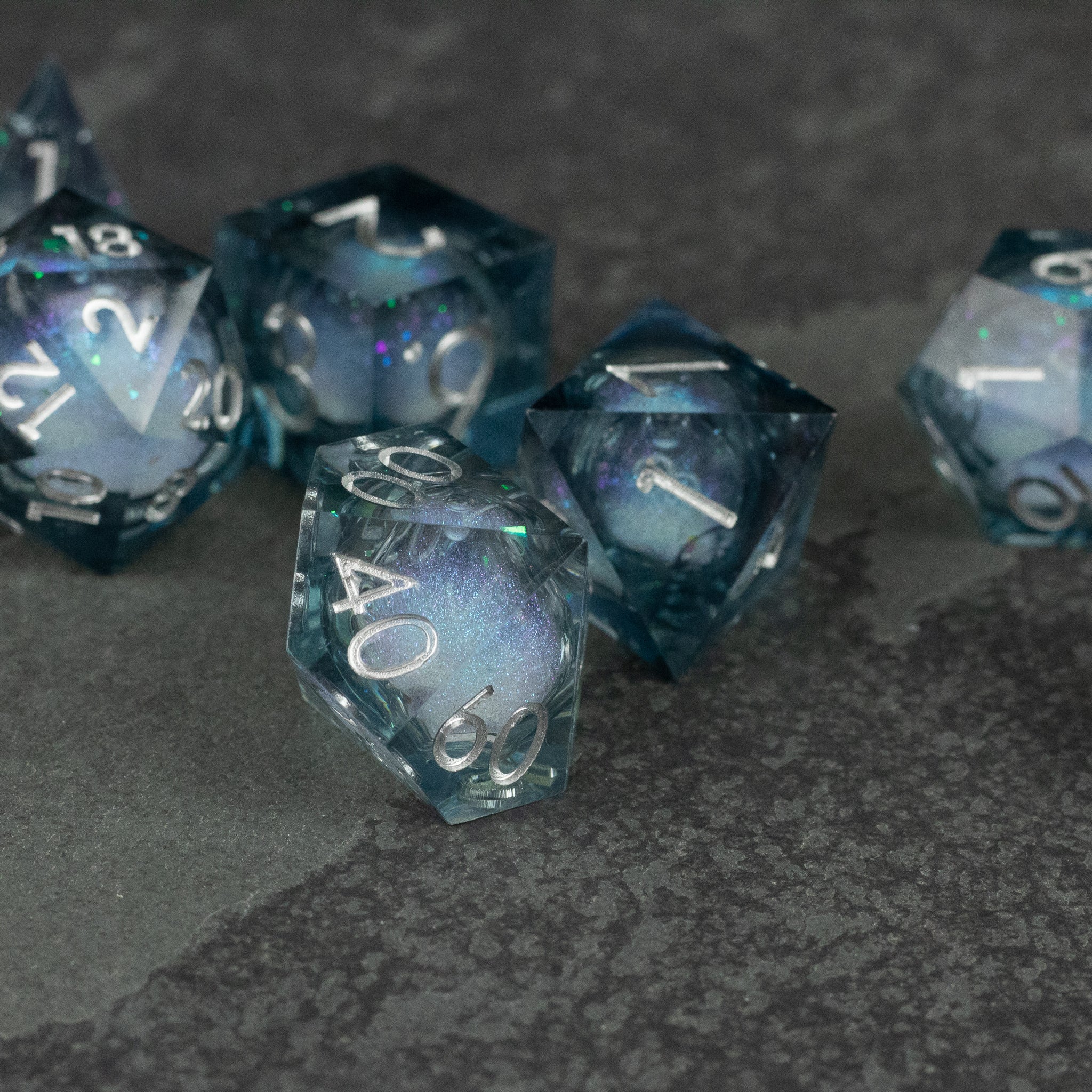 Astral Sea Liquid Core Dice Set - Translucent dark blue liquid core polyhedral dice set with sharp edges and white numbering.