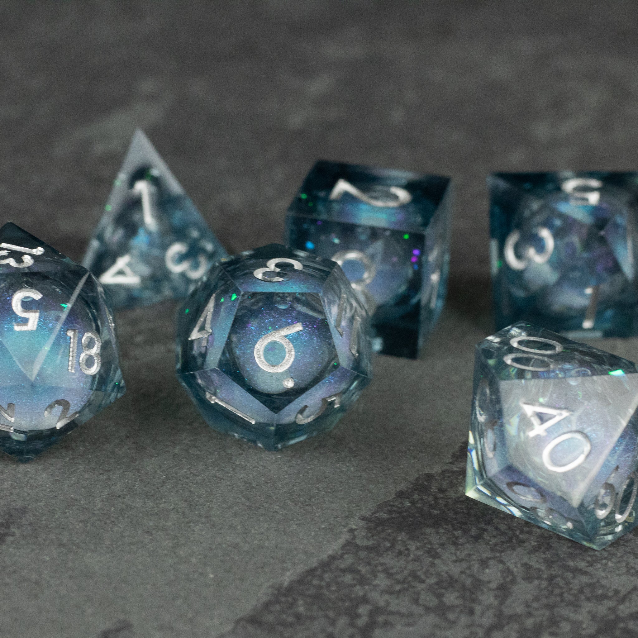 Astral Sea Liquid Core Dice Set - Translucent blue liquid core polyhedral dice set with sharp edges and white numbering.