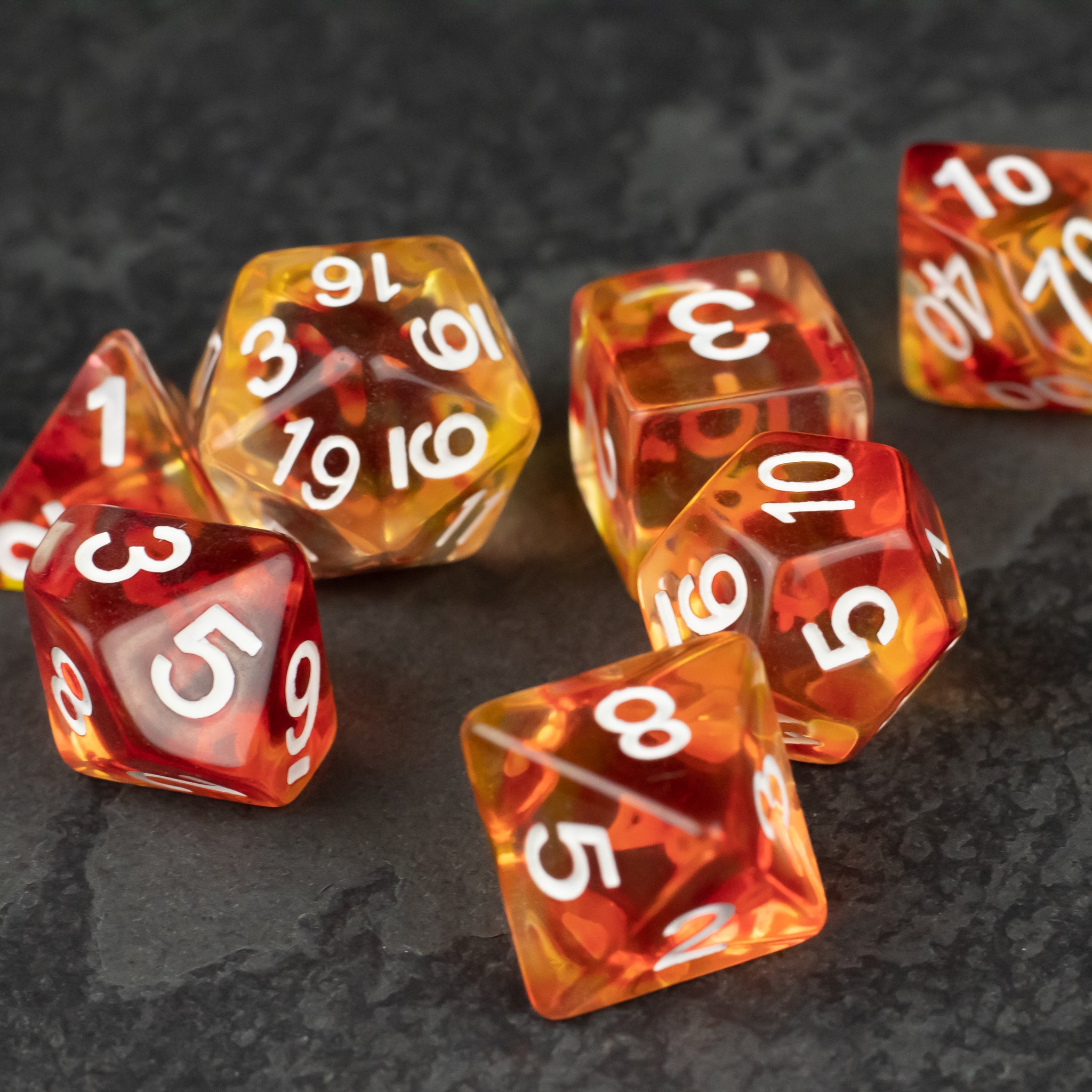 Magma Dice Set - Seven translucent polyhedral dice with swirling red and orange magma-like colors and white numbers.