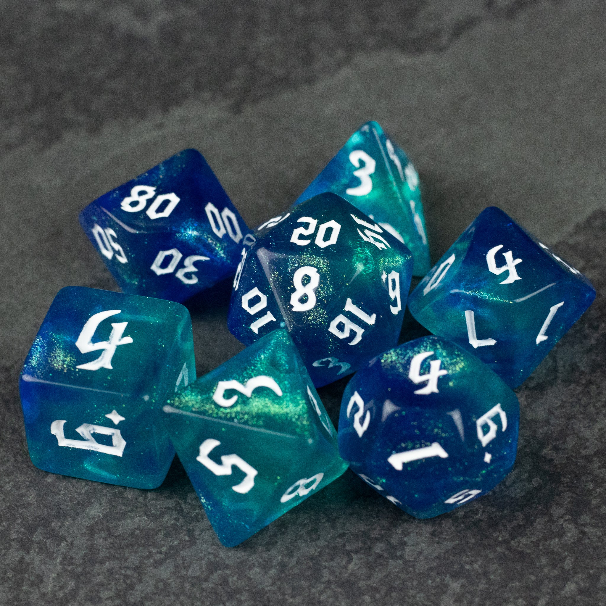 Blue & Green Glitter Dice Set - Set of blue and green translucent glitter dice with white numbering, includes multiple polyhedral shapes.