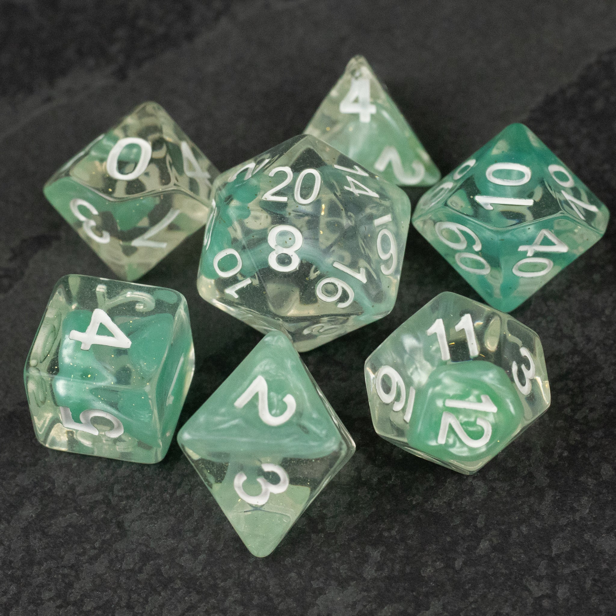 Cyan Lava Lamp Dice Set - Set of seven cyan translucent polyhedral dice with white numbering, including d20, d12, d10, d8, d6, d4, and a percentile.