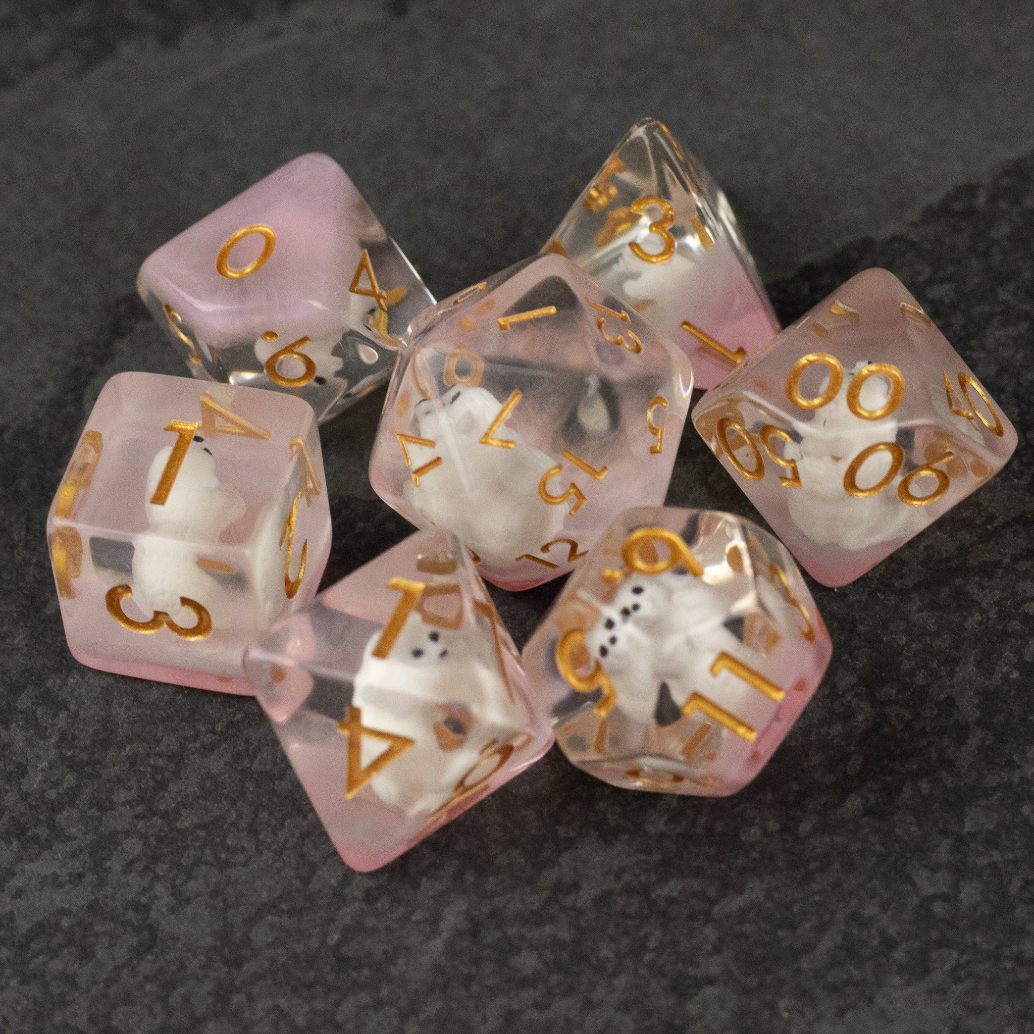 Polar Bear Dice Set - Set of seven translucent pink polyhedral dice with gold numbers, designed for tabletop games.