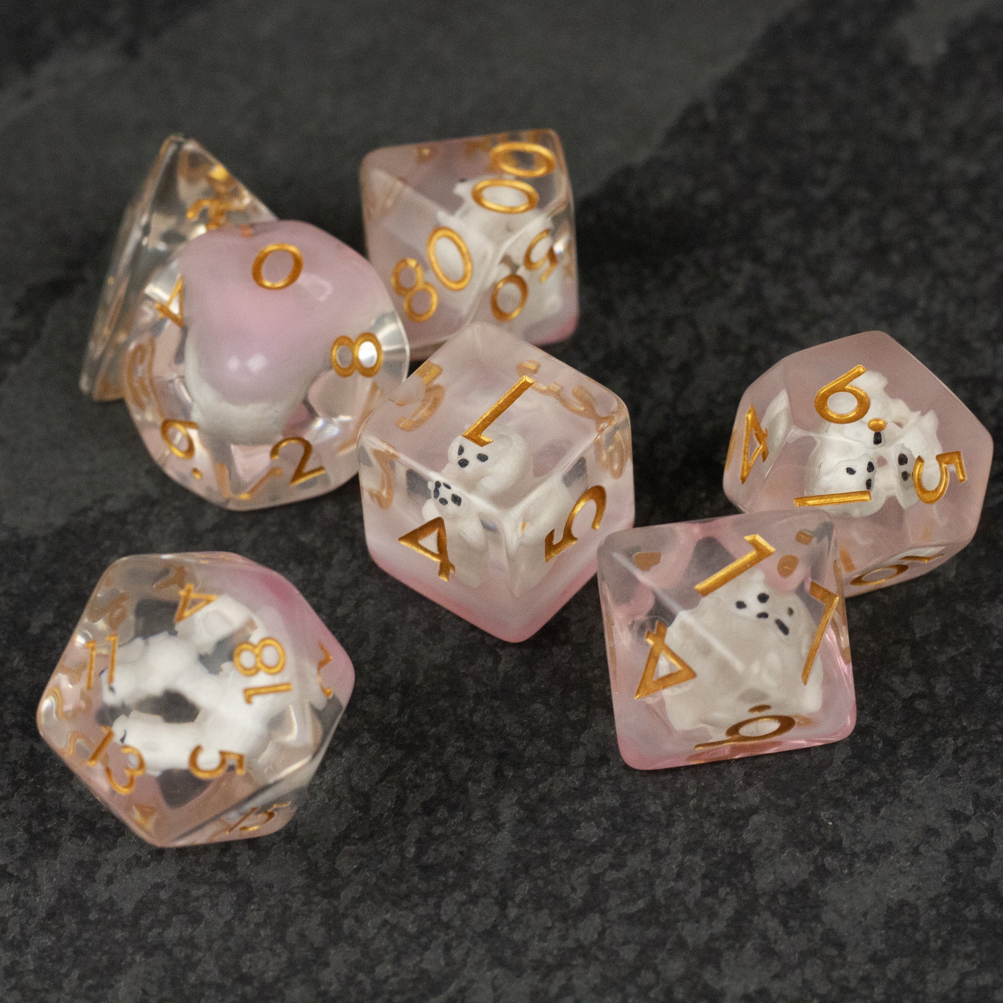 Polar Bear Dice Set - Translucent pink and clear polyhedral dice set with gold numbering, featuring a polar bear design inside some dice.
