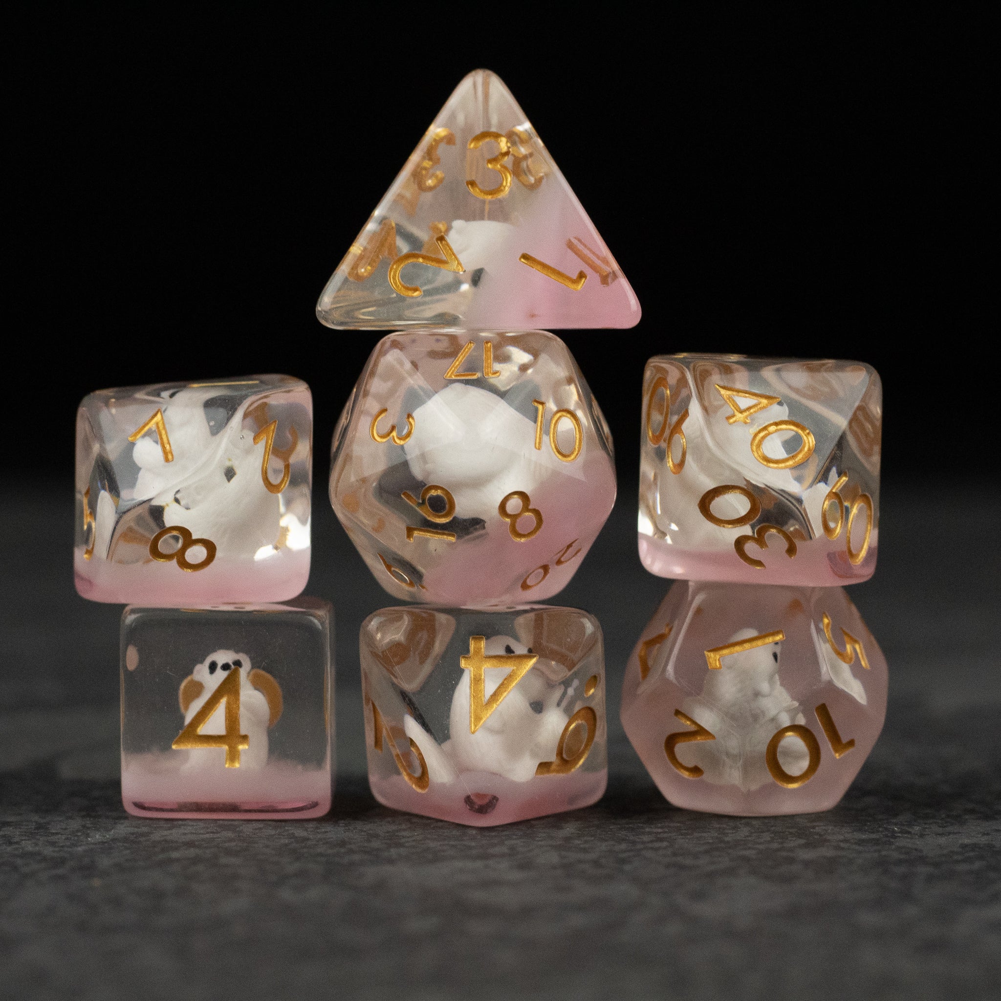 Polar Bear Dice Set - Set of seven translucent dice with white and pink swirls and gold numbering, including various polygon shapes.
