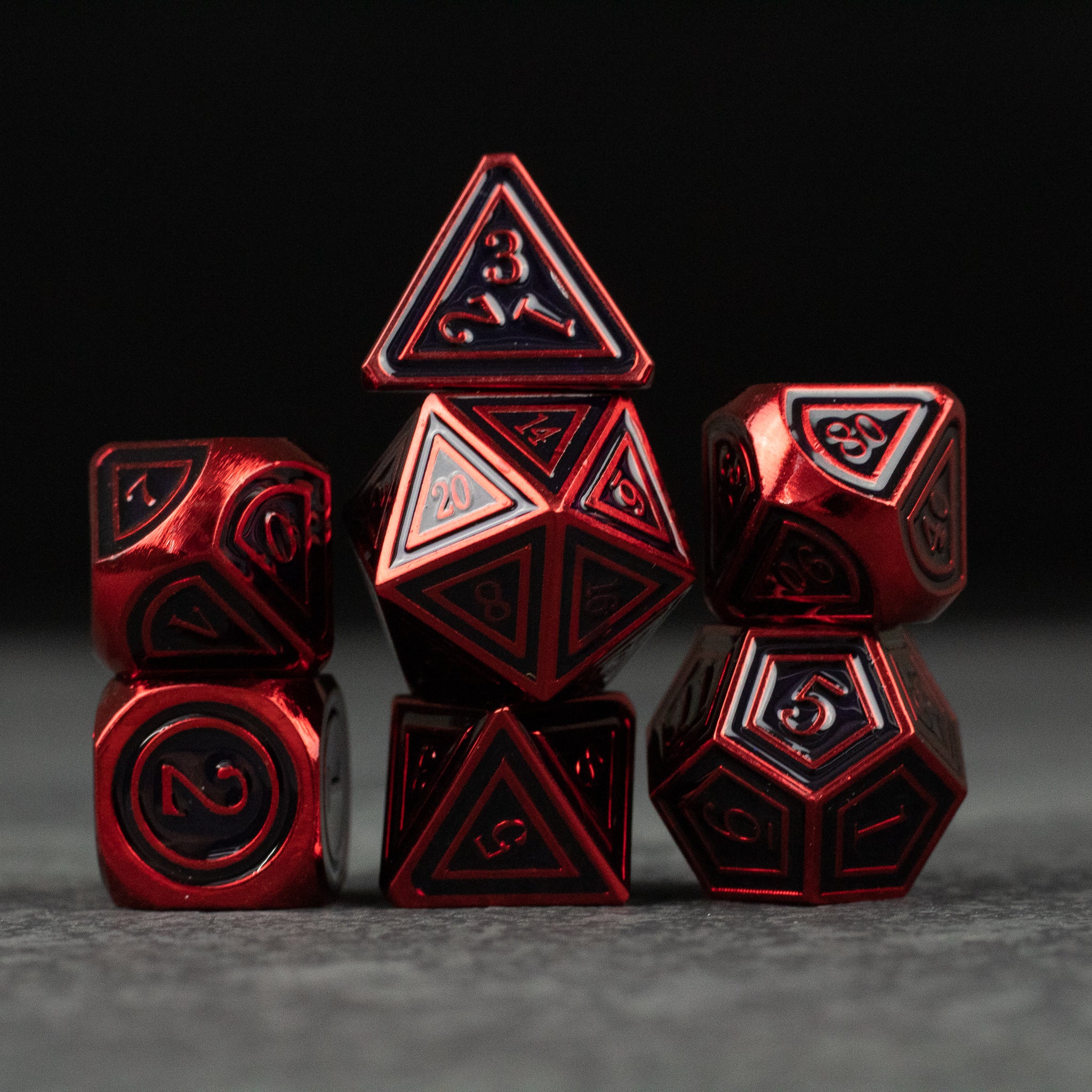 Crimson Ritual Dice Set - Set of seven metal dice with deep red finish and black engraved numbers, intricate geometric designs on each face.