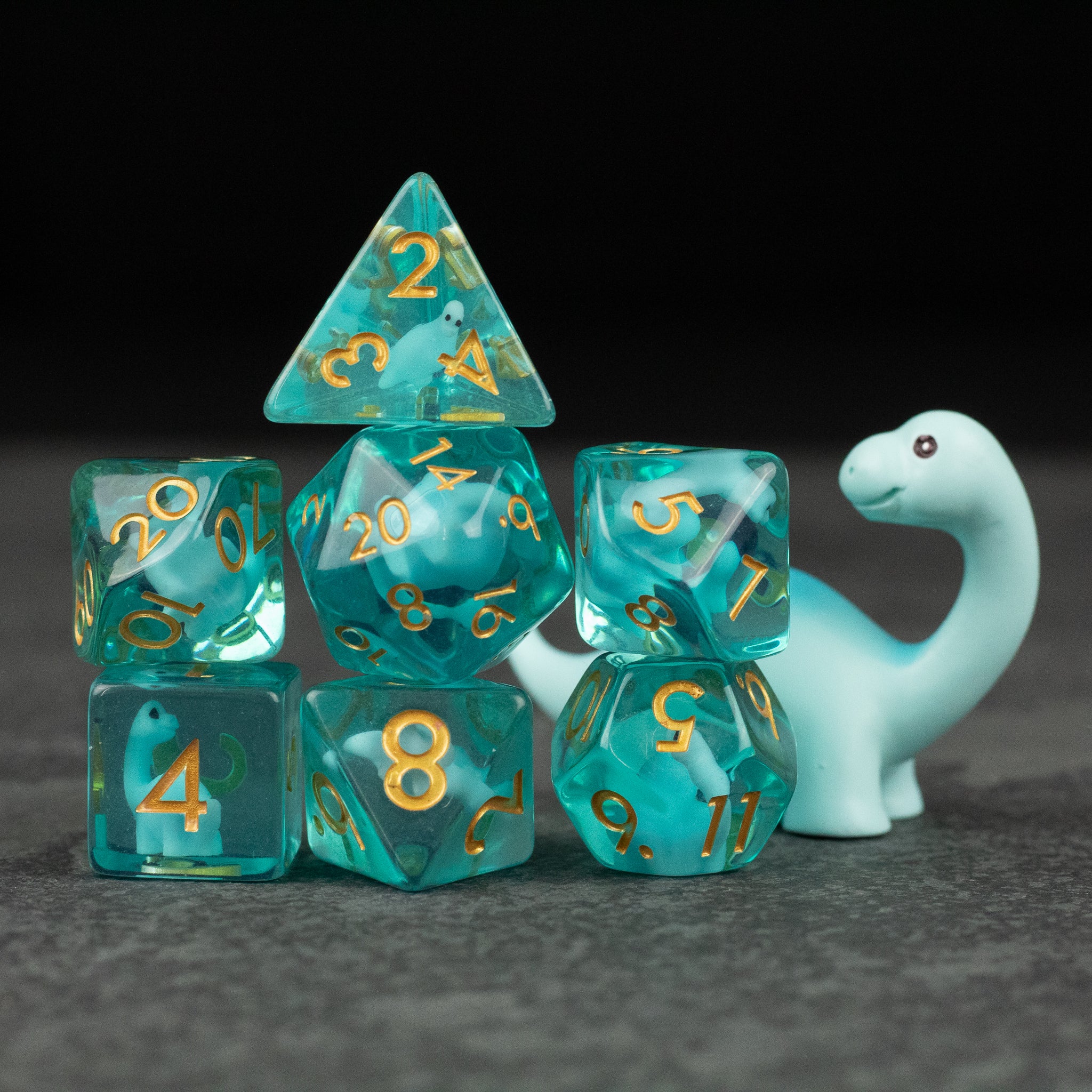 Blue Brontosaurus Dice Set - Turquoise marbled polyhedral dice set with gold numbers and a small blue brontosaurus figure.