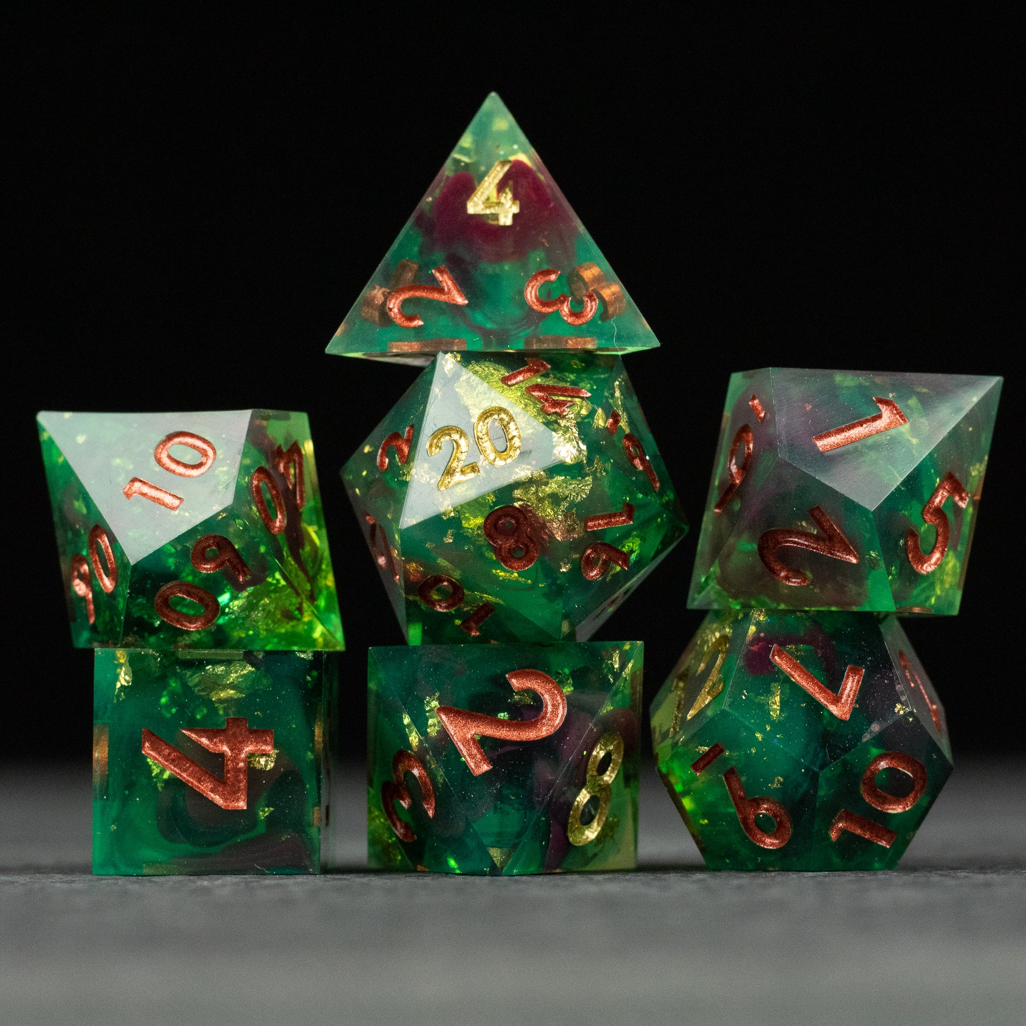 Primal Blood Dice Set - Green and red marbled sharp-edged dice set with gold numbers, including d20, d12, d10, d8, d6, and d4.