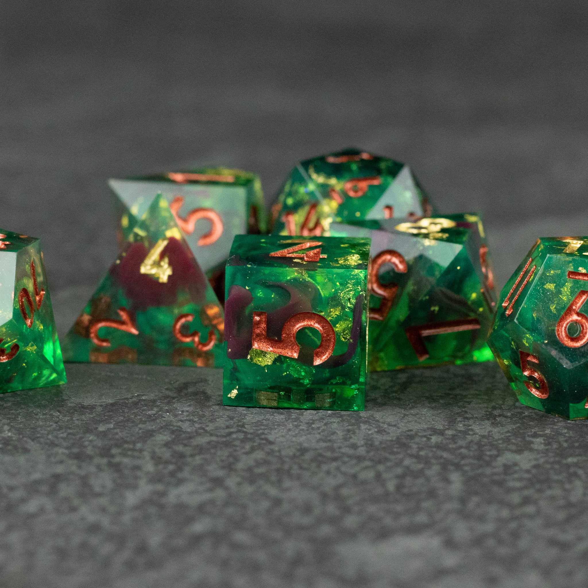 Primal Blood Dice Set - Translucent green sharp-edged polyhedral dice set with red and gold numbering.