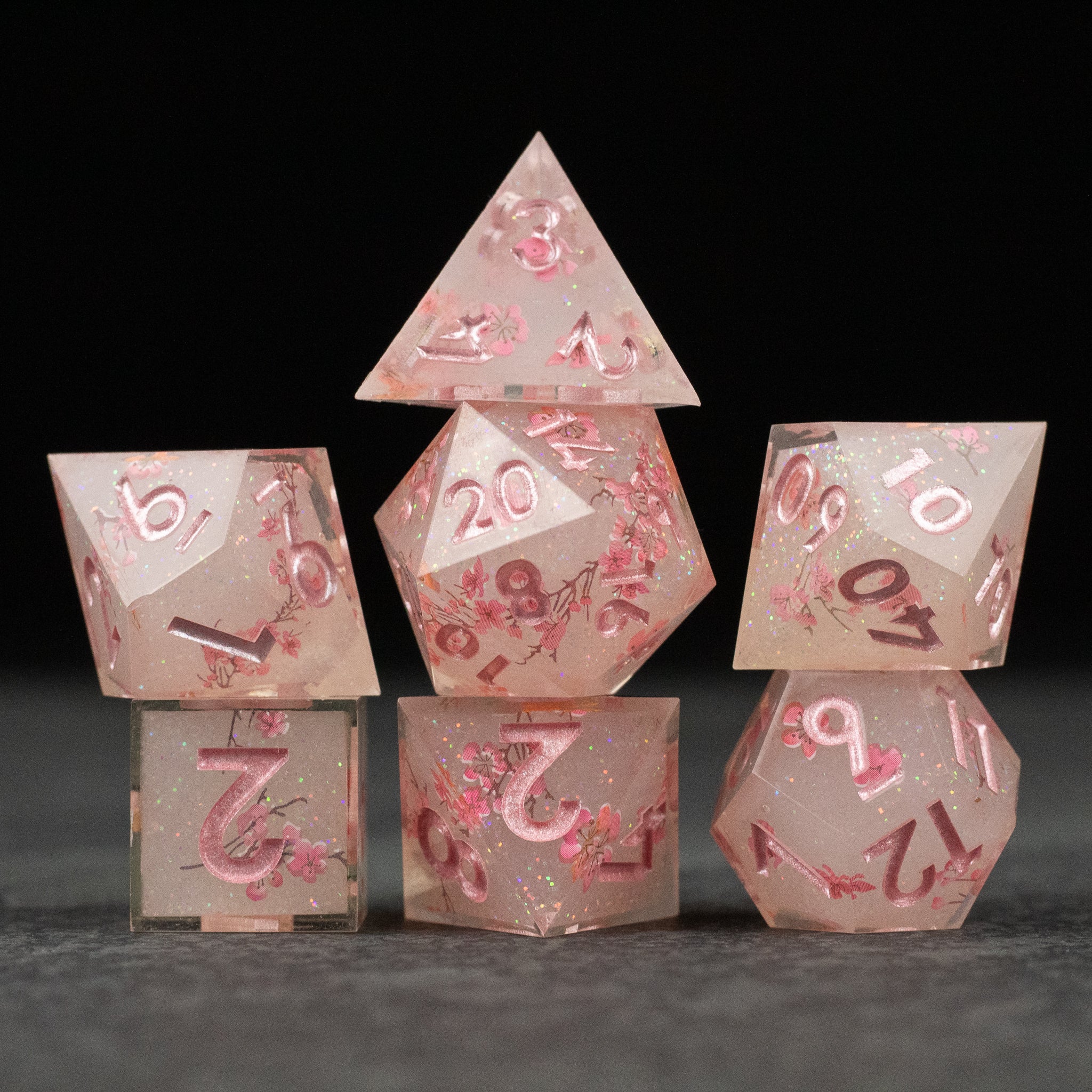 Pink Cherry Blossom Dice Set - Pink translucent dice set with cherry blossom petals and sharp edges, pink numbering.
