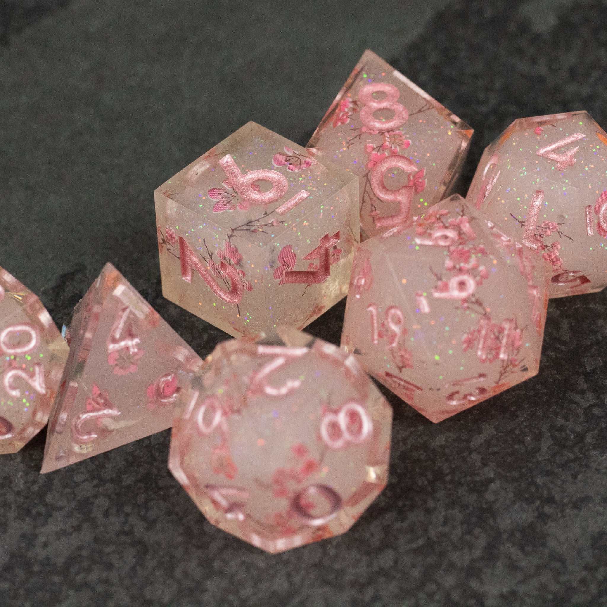 Pink Cherry Blossom Dice Set - Translucent pink sharp-edged polyhedral dice set with cherry blossom petals inside.
