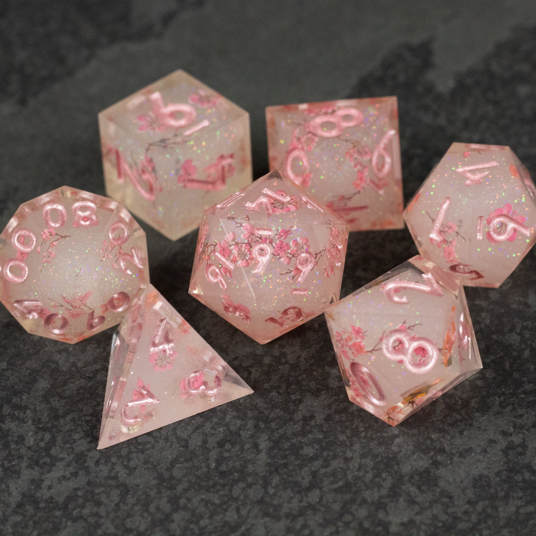 Pink Cherry Blossom Dice Set - Translucent pink sharp-edged dice with white cherry blossom patterns and pink numbers, seven-piece set.