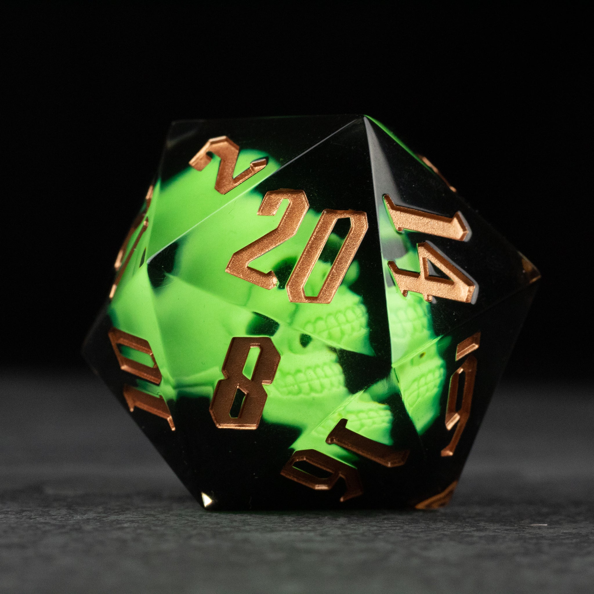 Giant 55mm D20 - Glowing Skull - Large 55mm translucent resin D20 dice with glowing green interior and bronze numbers.