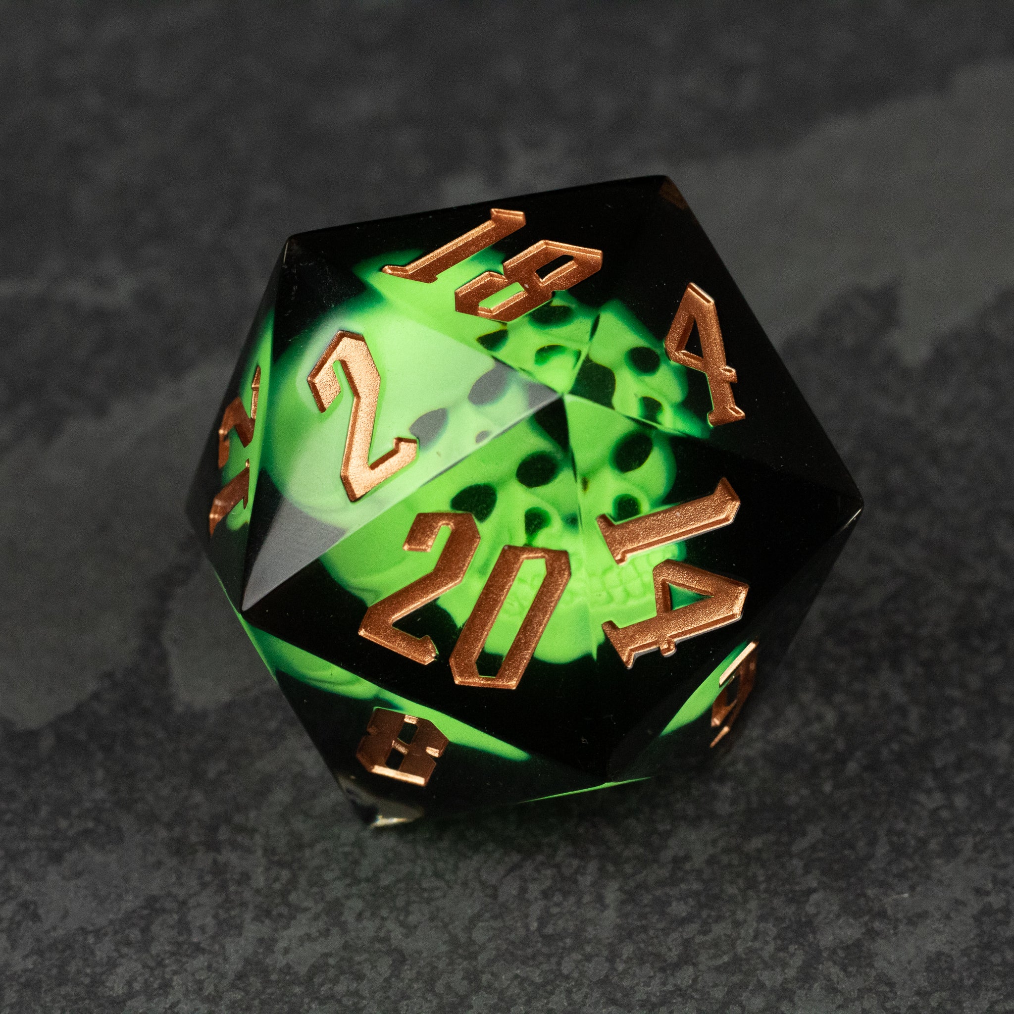 Giant 55mm D20 - Glowing Skull - 55mm translucent green resin d20 dice with glowing skull design and metallic gold numbers.