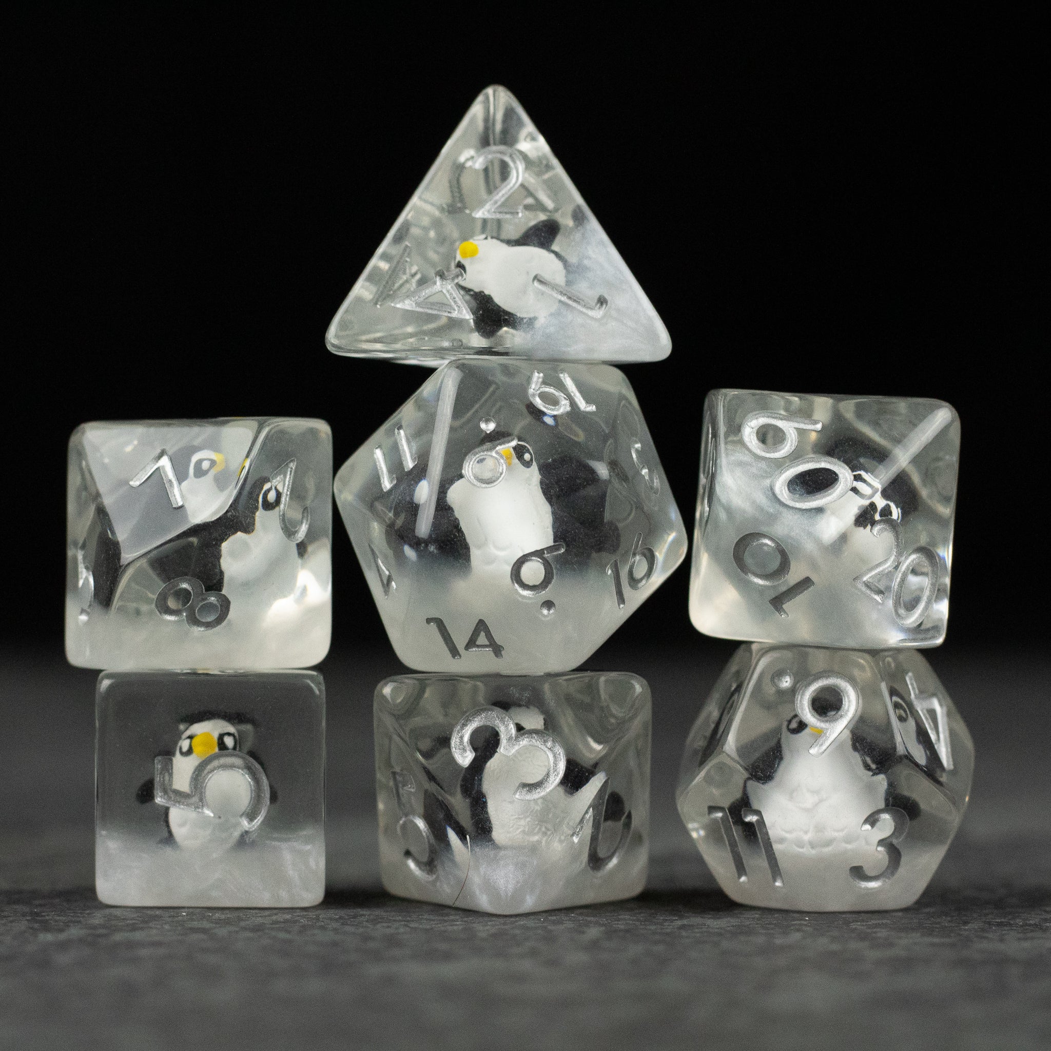 Penguin Dice Set - Clear polyhedral dice set with embedded miniature penguins, black and white details, silver numbering.