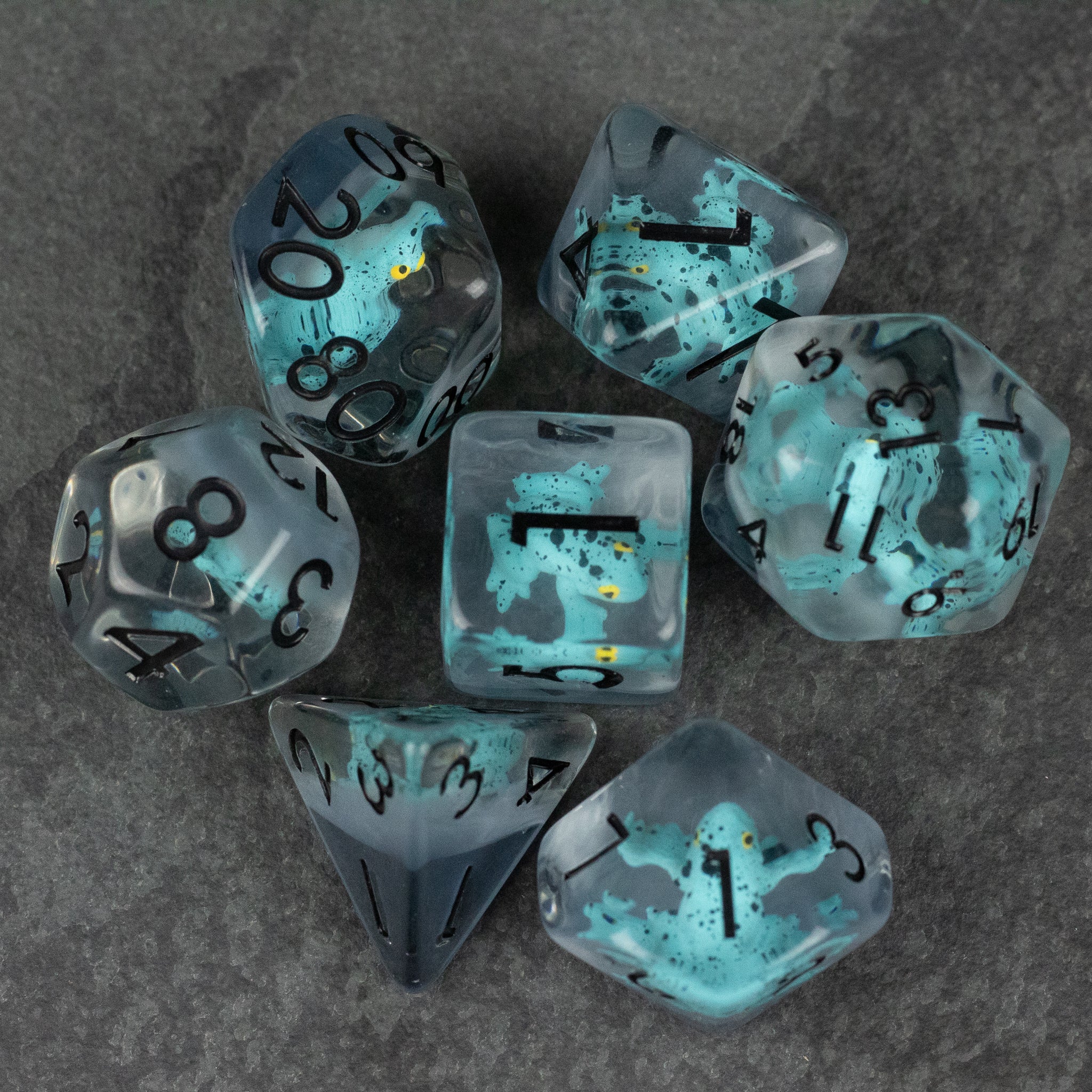 Blue Frog Dice Set - Translucent blue polyhedral dice set with black numbers and small frog shapes inside on a dark surface.