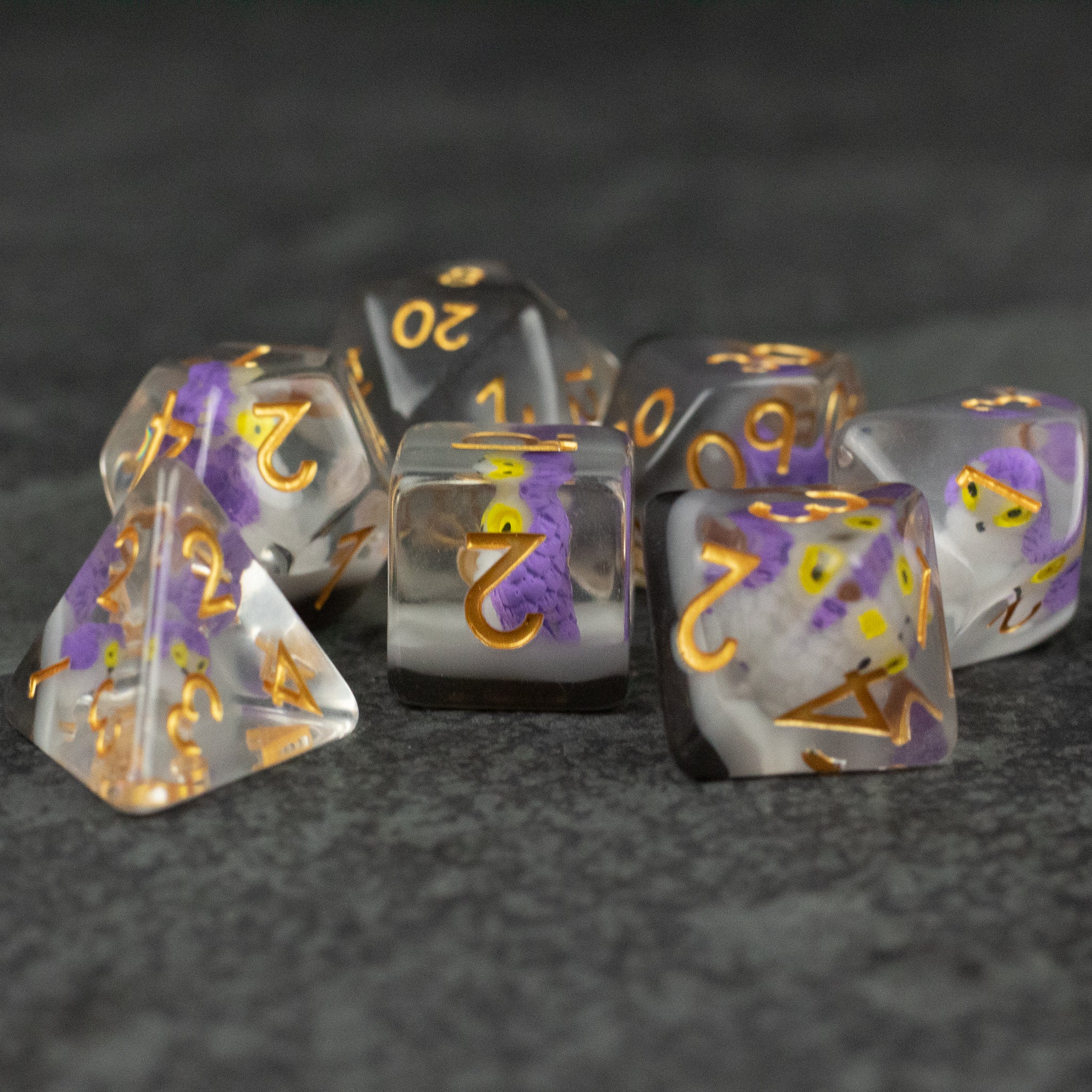 Purple Owl Dice Set - Seven translucent purple and white polyhedral dice with gold numbers, including d4, d6, d8, d10, d12, and d20 shapes.