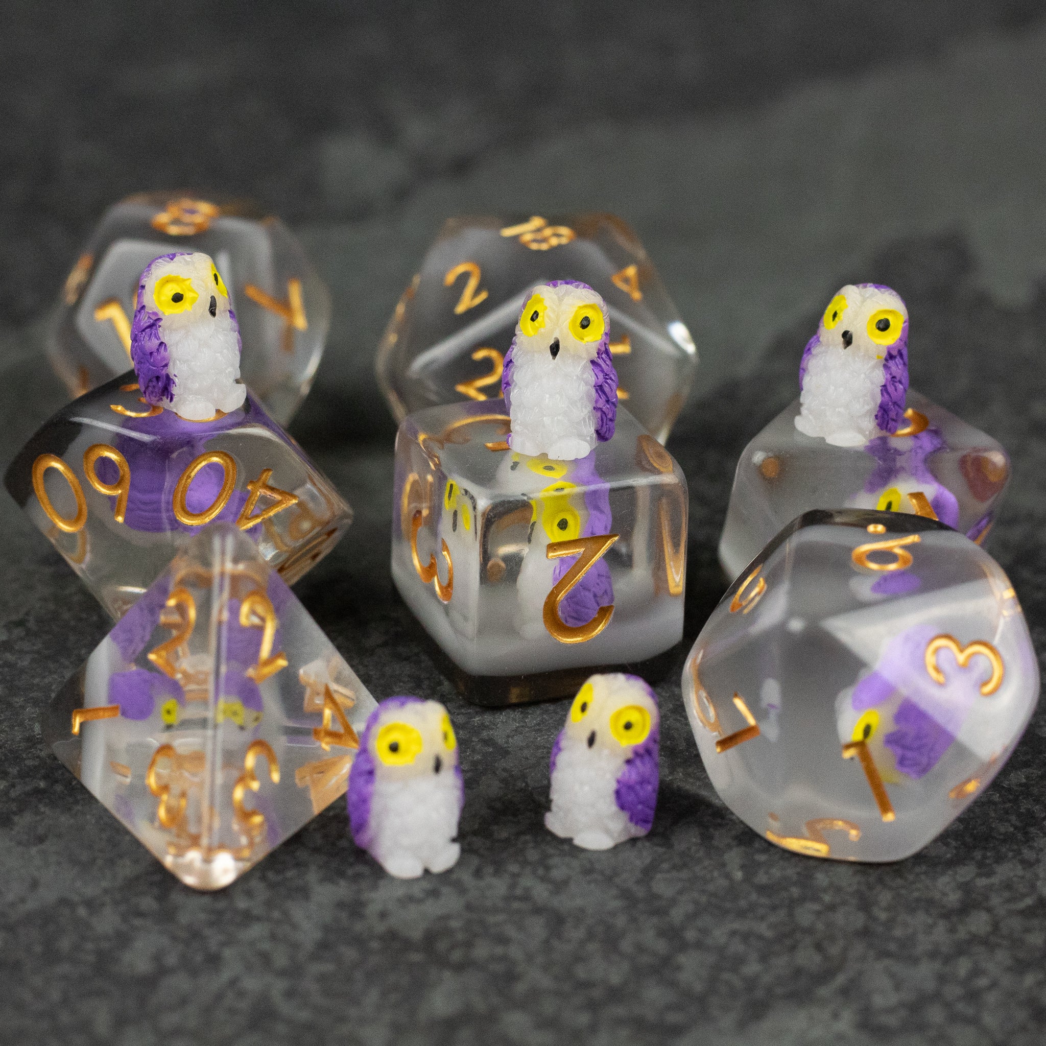 Purple Owl Dice Set - Set of transparent purple owl-themed polyhedral dice with gold numbering and small owl figurines.