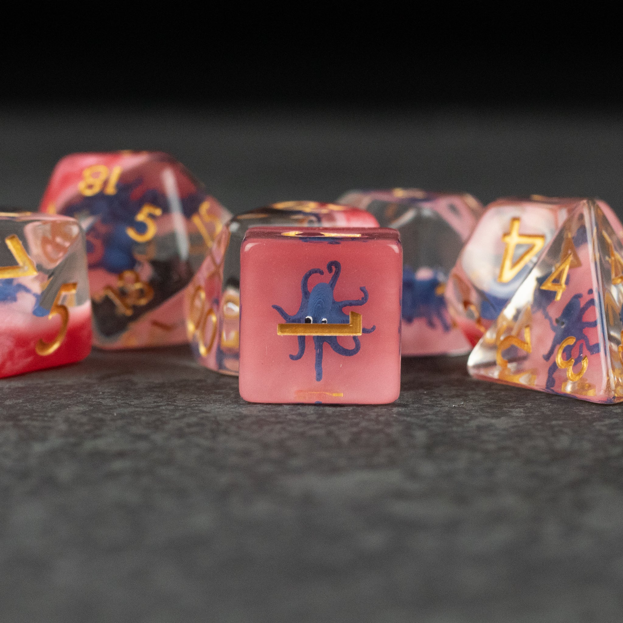 Dark Blue Octopus Dice Set - Dark blue and pink translucent polyhedral dice set with octopus design on the d6.